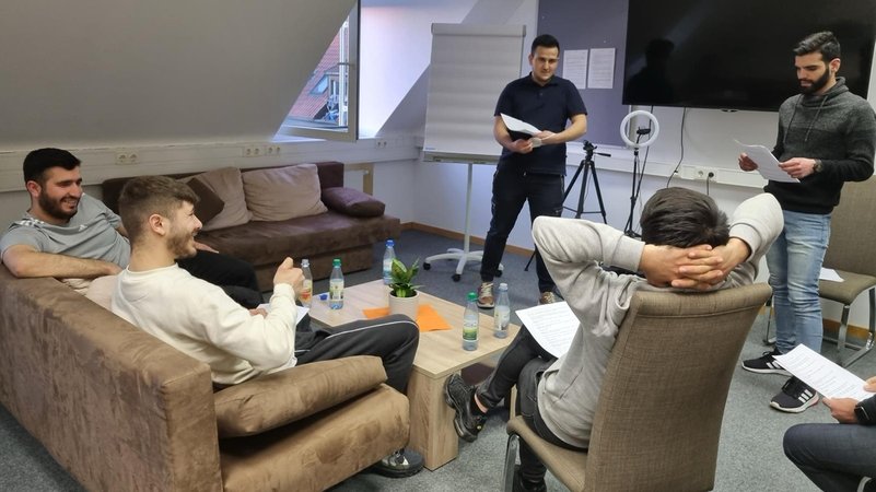 Junge Männer sitzen in einer Gruppenstunde in einem Seminarraum zusammen. | Bild: Projekt Heroes Schweinfurt Junge Männer sitzen in einer Gruppenstunde in einem Seminarraum zusammen.
