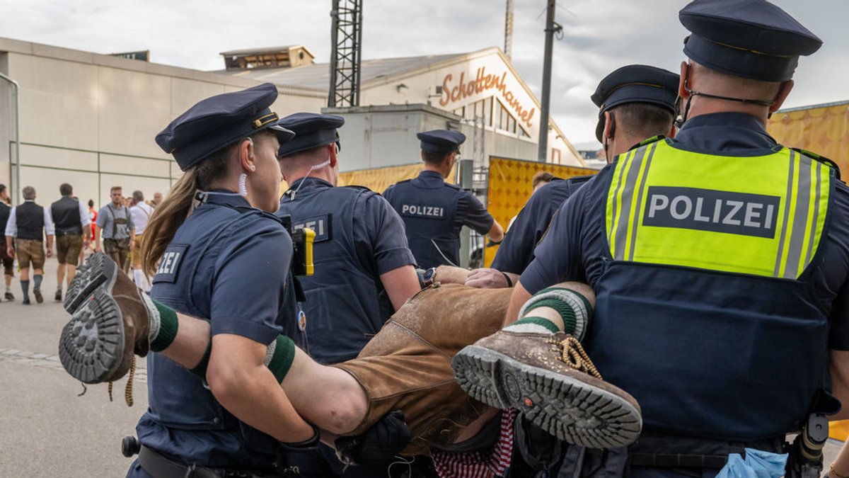 Polizeibeamte der Wiesn-Streife führen auf dem Oktoberfestgelände einen randalierenden und stark angetrunkenen Mann zur Polizeiwache. 
