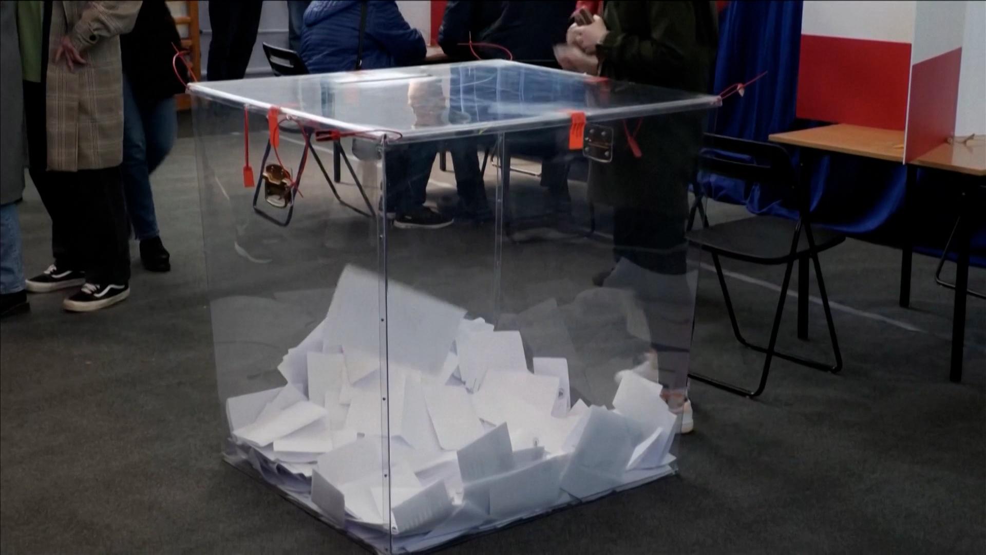 Stimmzettel liegen in einer durchsichtigen Wahlurne.