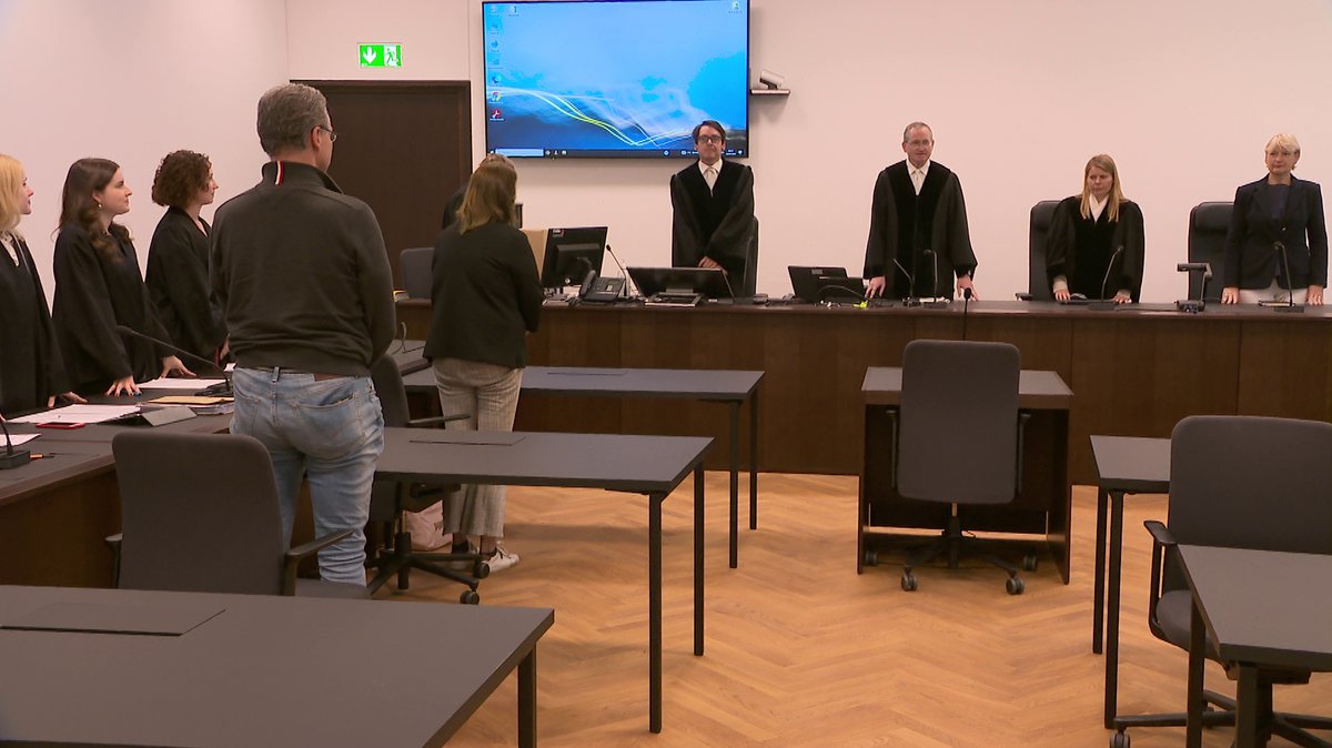 Angeklagte stehen vor Gericht als die Kammer den Saal betritt