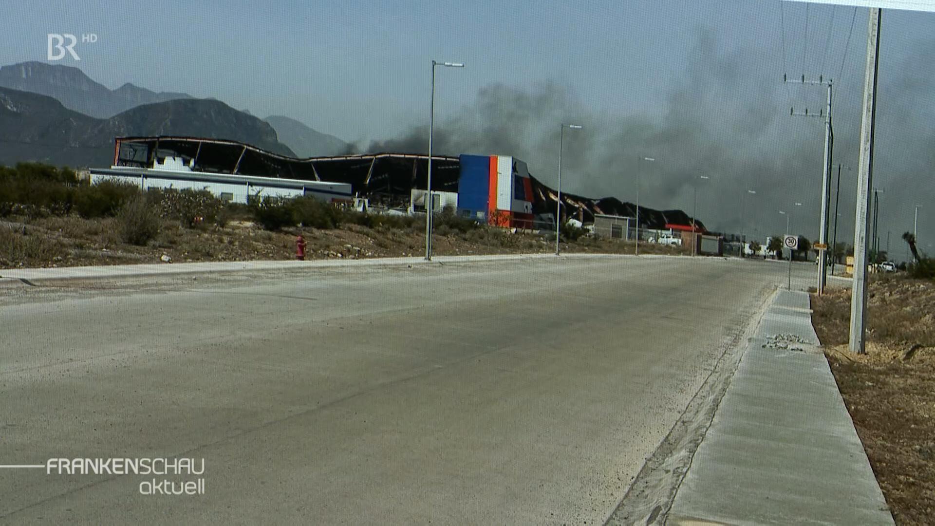 Aus einer Industriehalle steigt Qualm auf.