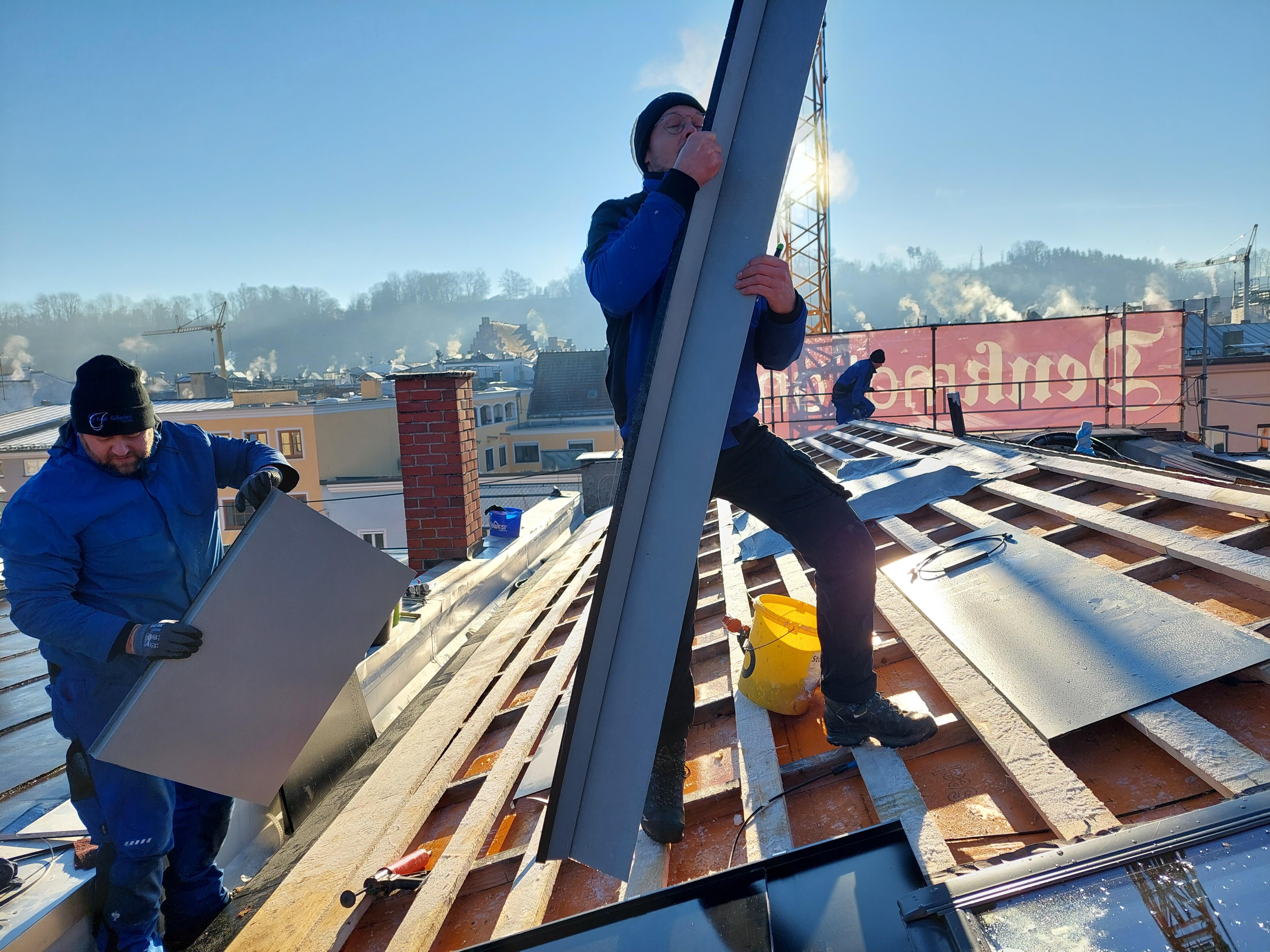 Mitarbeiter der Spenglerfirma Goepfert bei der Montage von Solarblechen auf dem Dach eines Hauses in der Altstadt von Wasserburg am Inn.