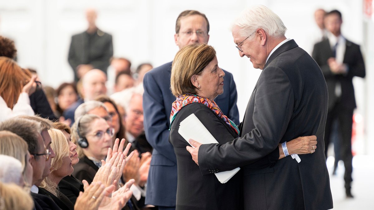Bundespräsident Frank-Walter Steinmeier und Sportler-Witwe Ankie Spitzer umarmen sich, im Hintergrund Israels Staatspräsident Jitzchak Herzog