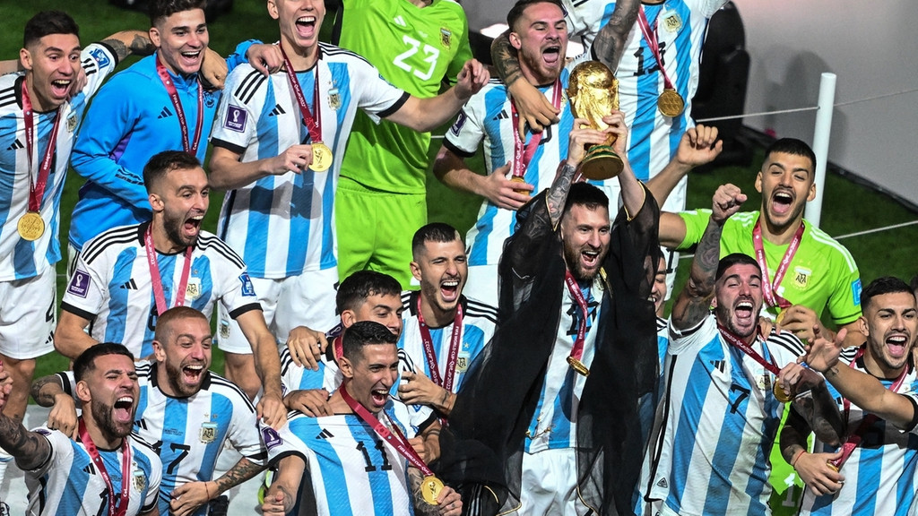 Argentiniens Lionel Messi und seine Mitspieler jubeln mit dem WM-Pokal. 