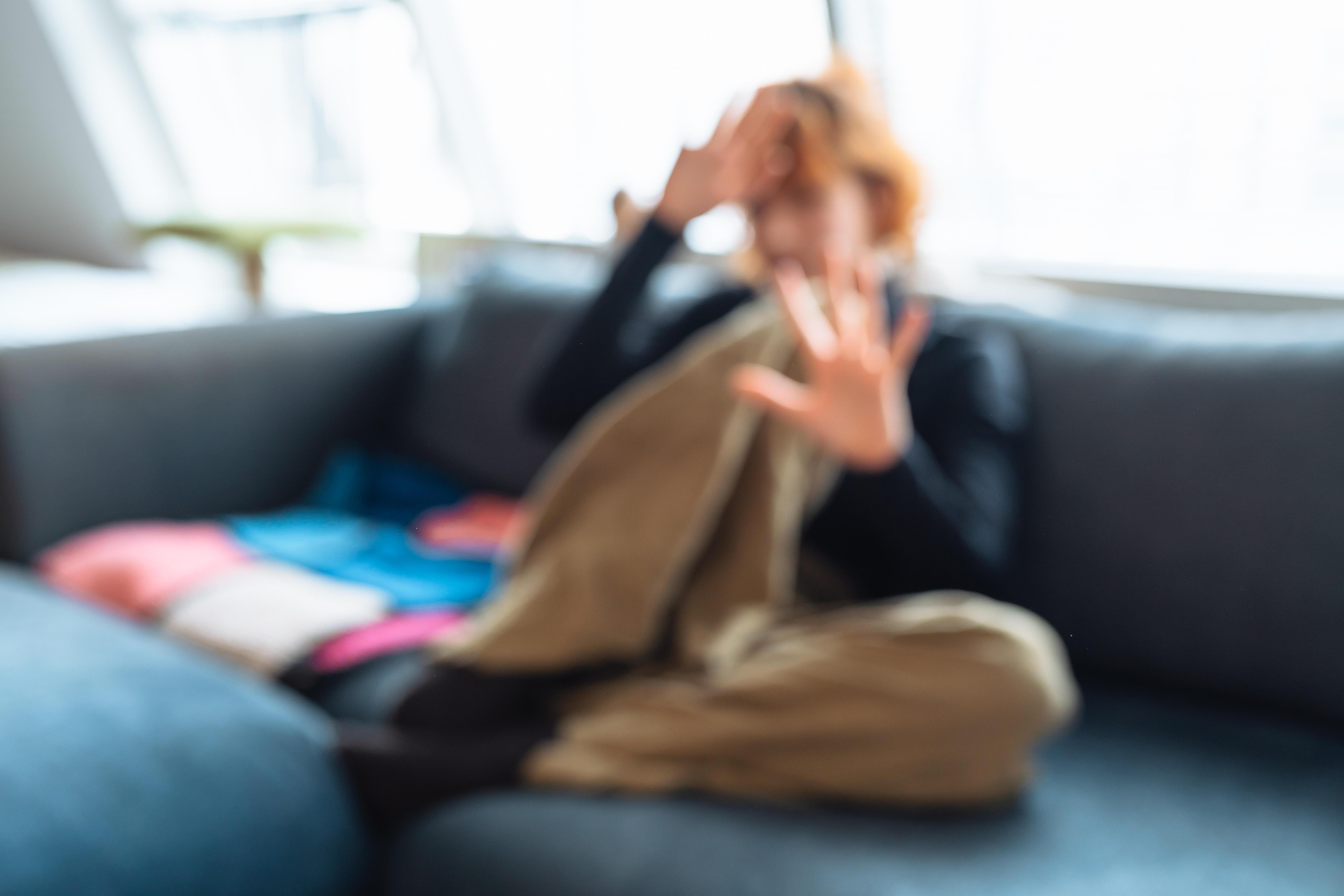 Symbolbild "Häusliche Gewalt": Frau hebt abwehrend die Hände