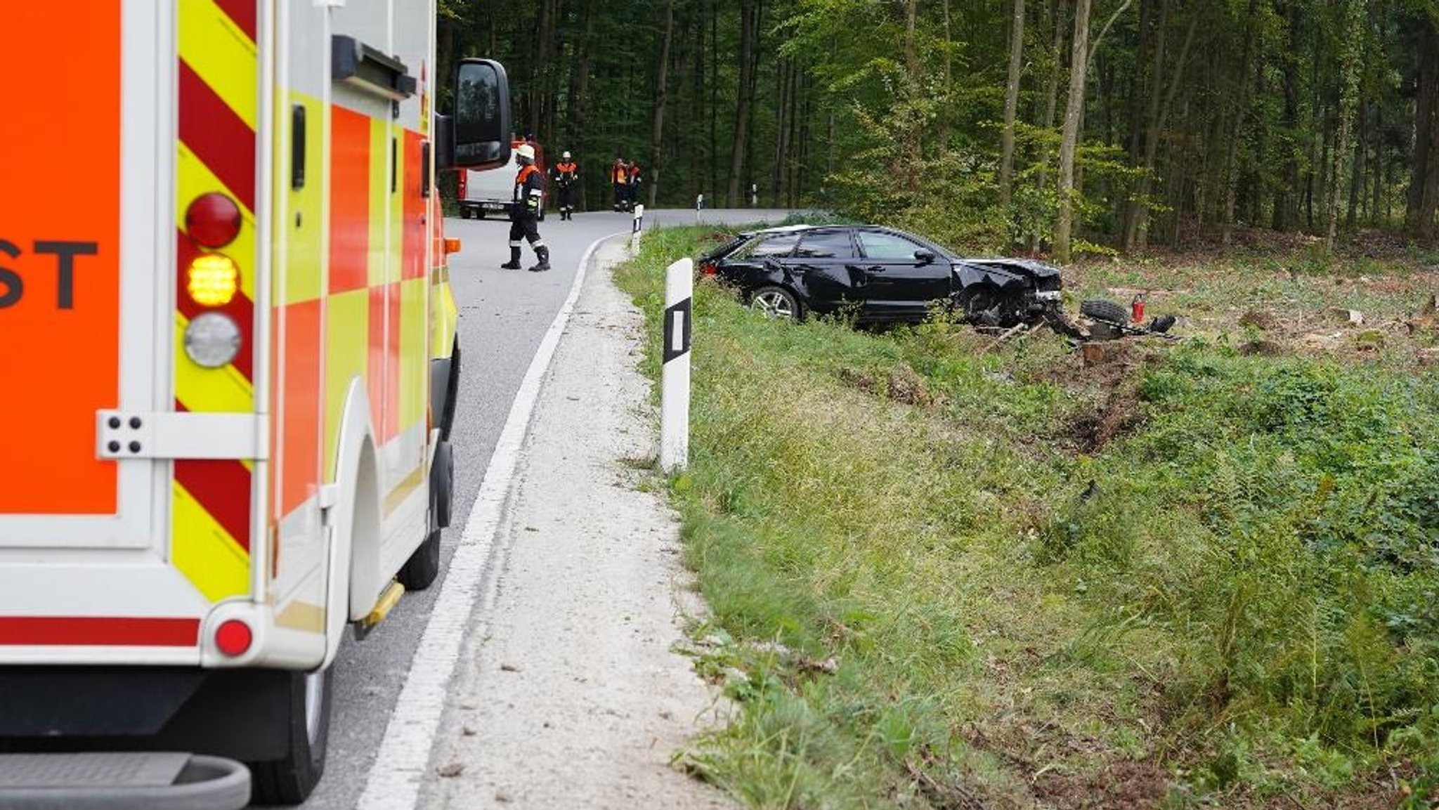 Unfallauto im Graben , im Vordergrund steht ein Krankenwagen