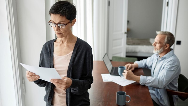 Ein paar sitzt und steht in ihrer Wohnung und informiert sich am Laptop und mit Dokumenten über ihre Rente. | Bild: picture alliance / Westend61 | SeventyFour Ein paar sitzt und steht in ihrer Wohnung und informiert sich am Laptop und mit Dokumenten über ihre Rente.