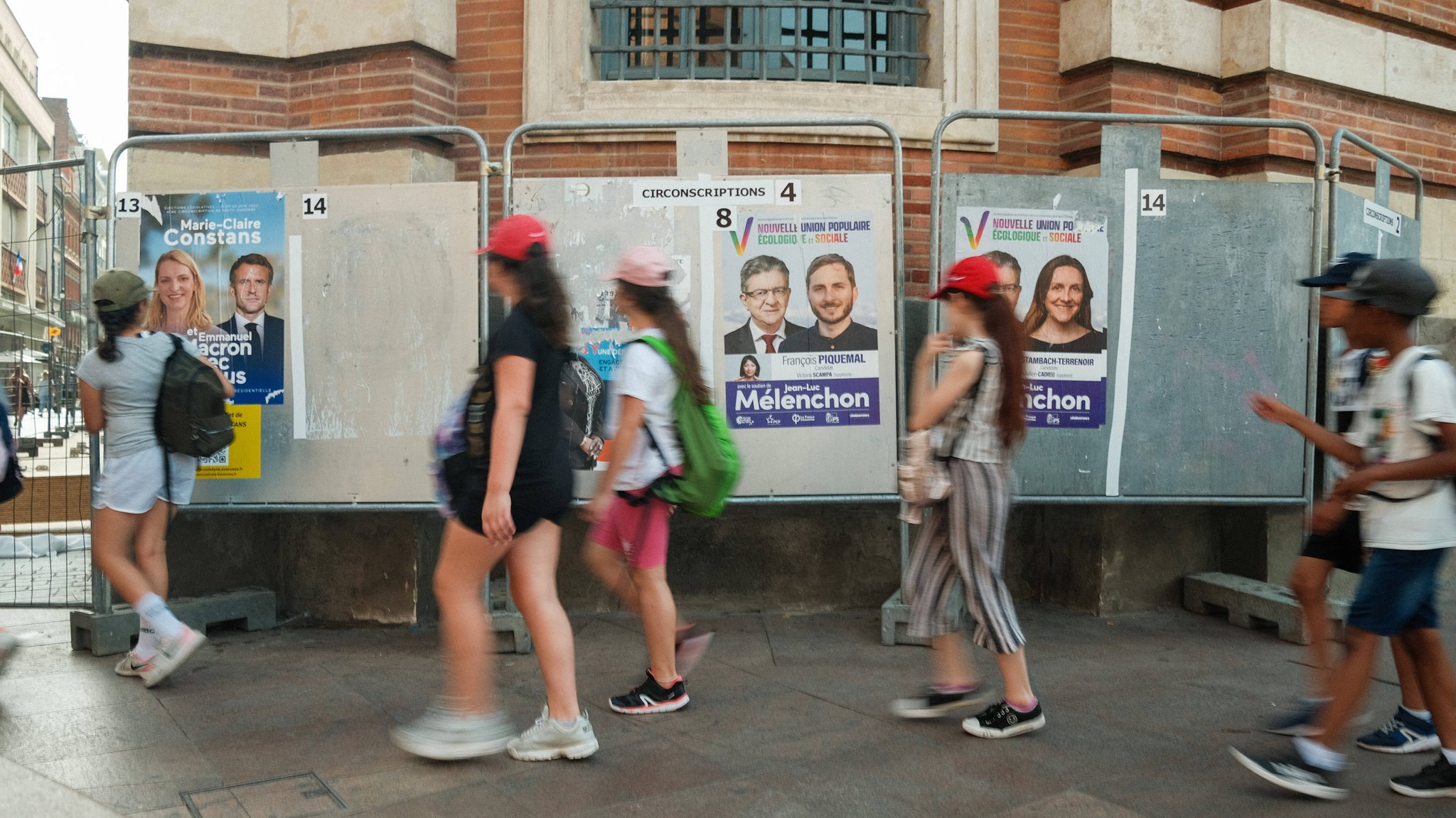 Kinder laufen an Wahlplakaten vorbei