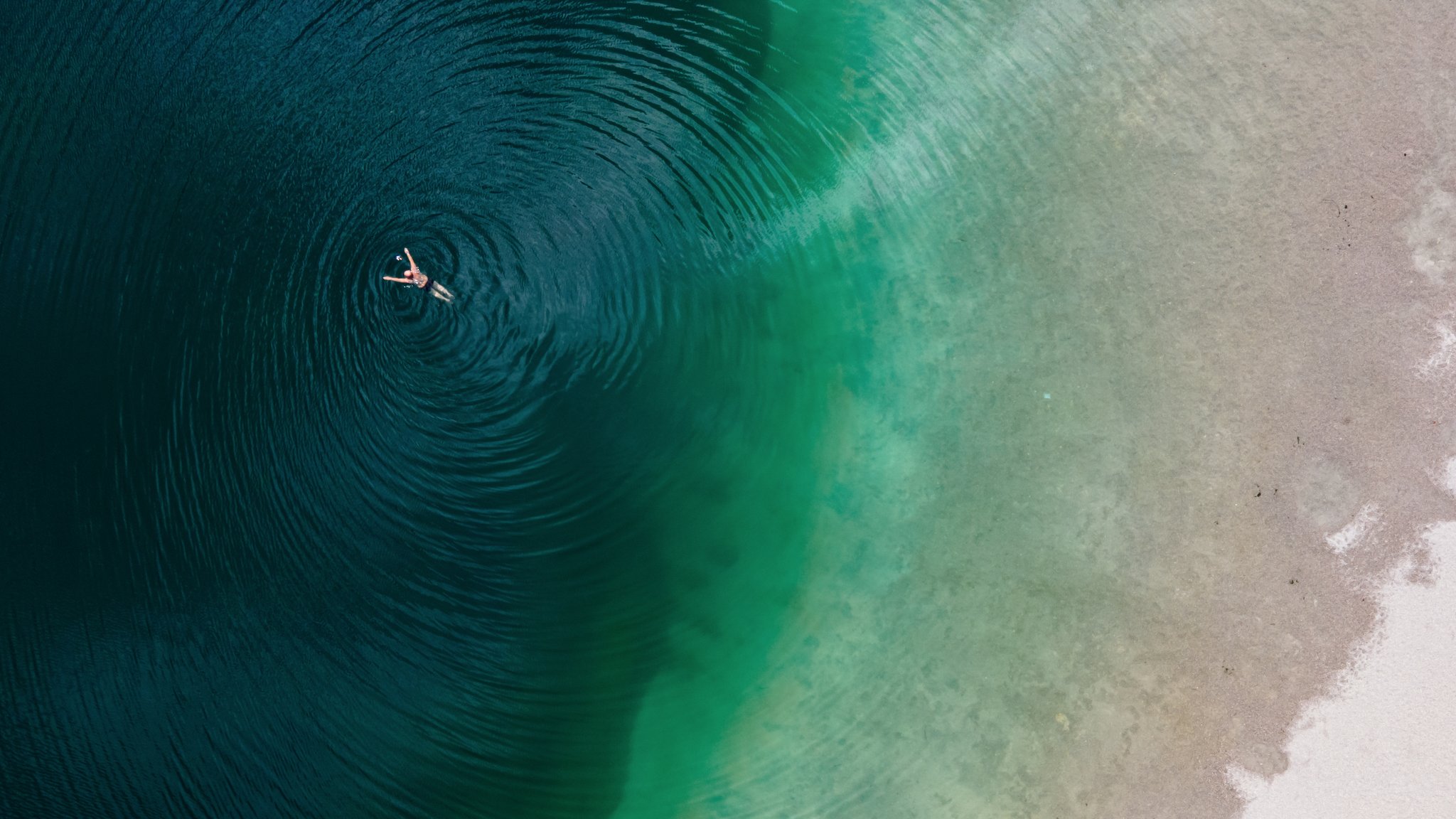 Ein Mann genießt das schöne Wetter und schwimmt im Langwieder See. (Luftaufnahme mit einer Drohne) | Bild: picture alliance/dpa | Sven Hoppe Ein Mann genießt das schöne Wetter und schwimmt im Langwieder See. (Luftaufnahme mit einer Drohne)