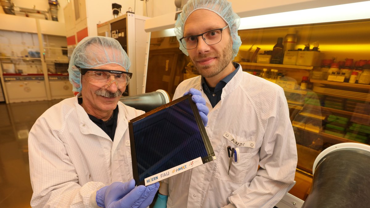 Zwei Forscher halten ein Solarmodul in der Hand.