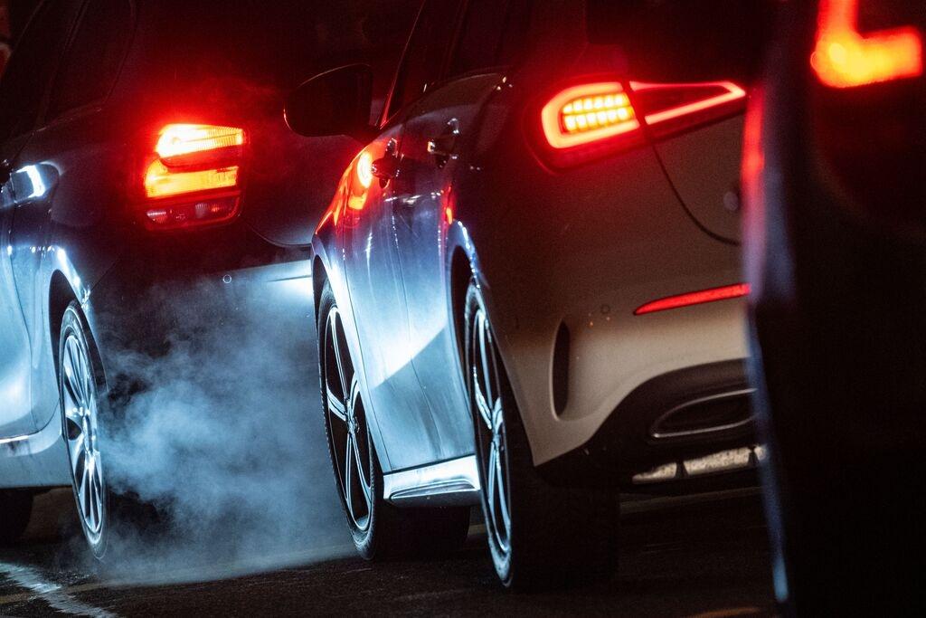 Autoabgase sind hinter einem Kraftfahrzeug im Straßenverkehr zu sehen.