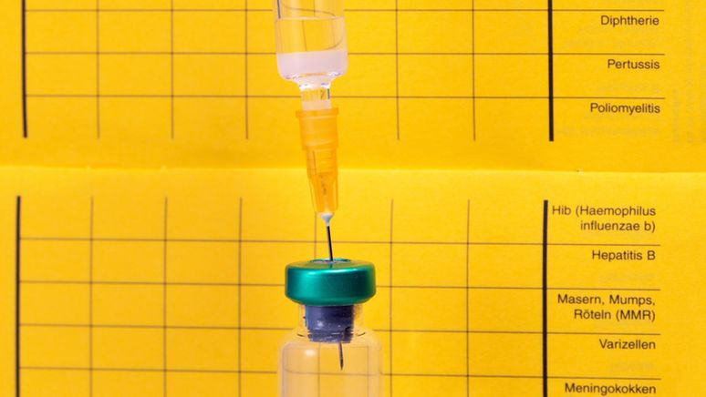 Eine Spritze vor einem Impfpass | Bild:pa/Zoonar/Smilla72!