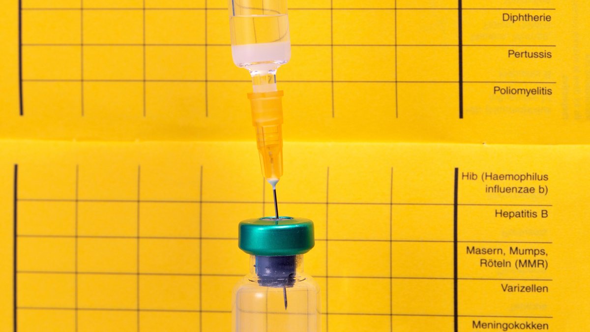 Eine Spritze vor einem Impfpass