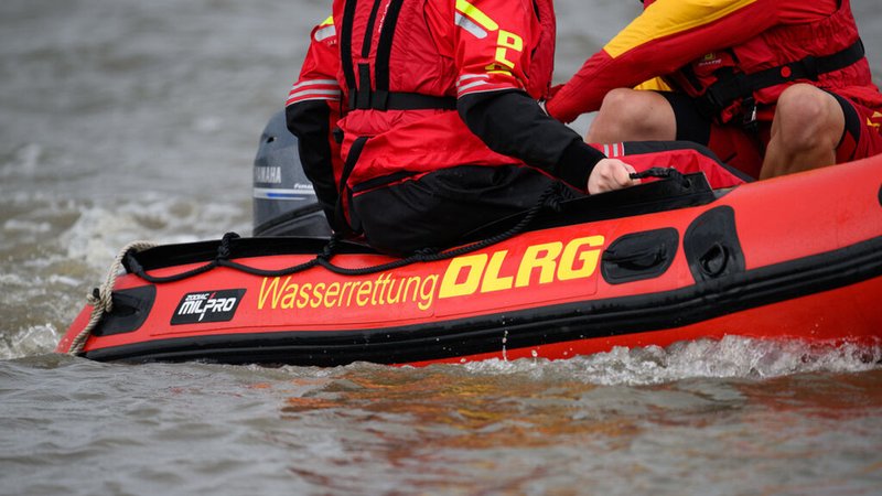 Zwei Mitarbeiter des DLRG fahren am Rande eines Pressegesprächs der Deutsche Lebens-Rettungs-Gesellschaft (DLRG) zum Thema "Todesfälle durch Ertrinken" während einer Präsentation mit einem Schlauchboot auf der Elbe. Foto: Daniel Reinhardt/dpa +++ dpa-Bildfunk +++
