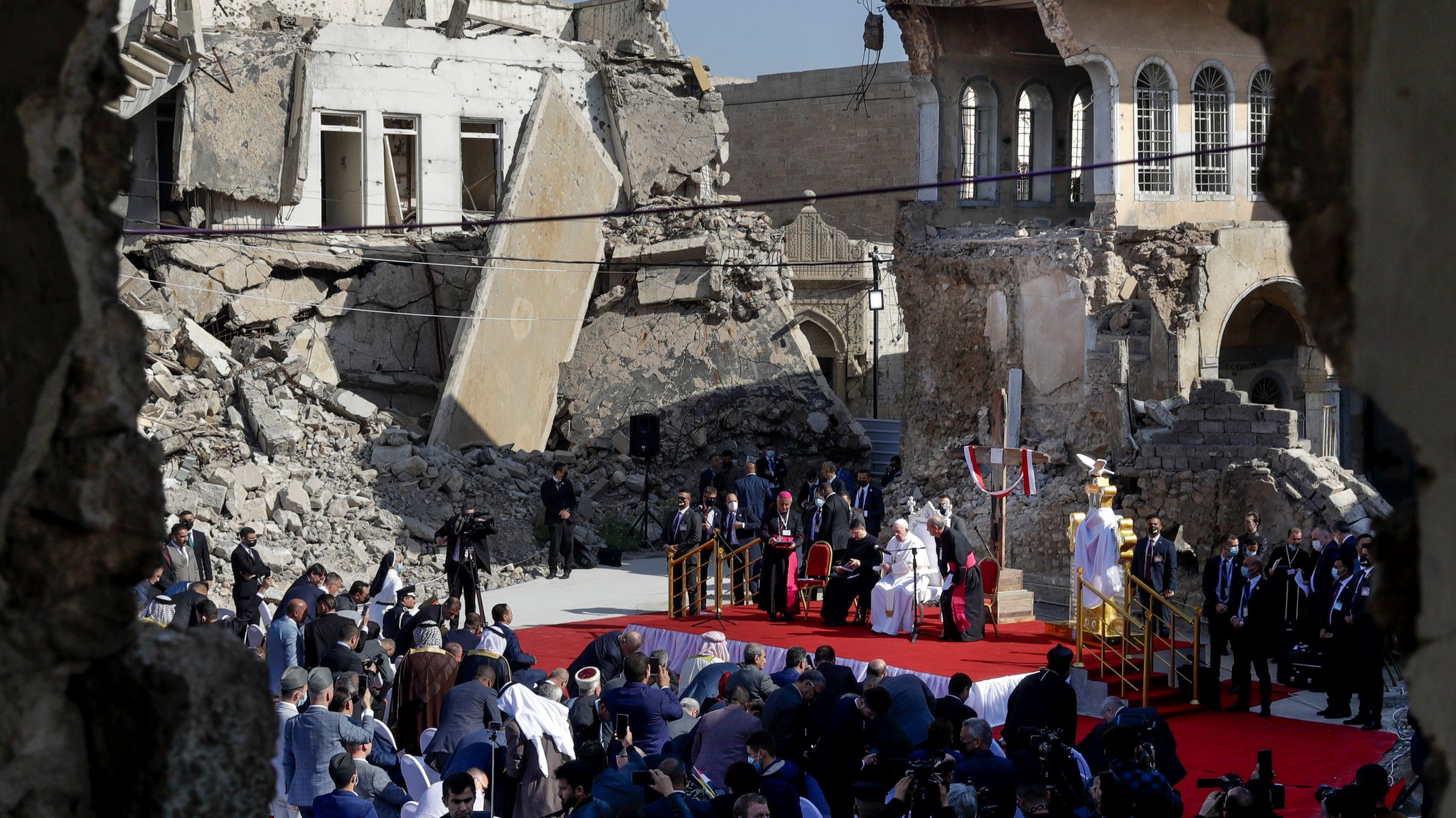 Papst Franziskus, umgeben von den Ruinen zerstörter Kirchen, betet für die Opfer des Krieges auf dem Hosh al-Bieaa-Kirchenplatz in Mosul 2021.