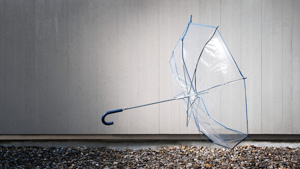 Ein durchsichtiger Regenschirm wird vom Wind weggeweht.