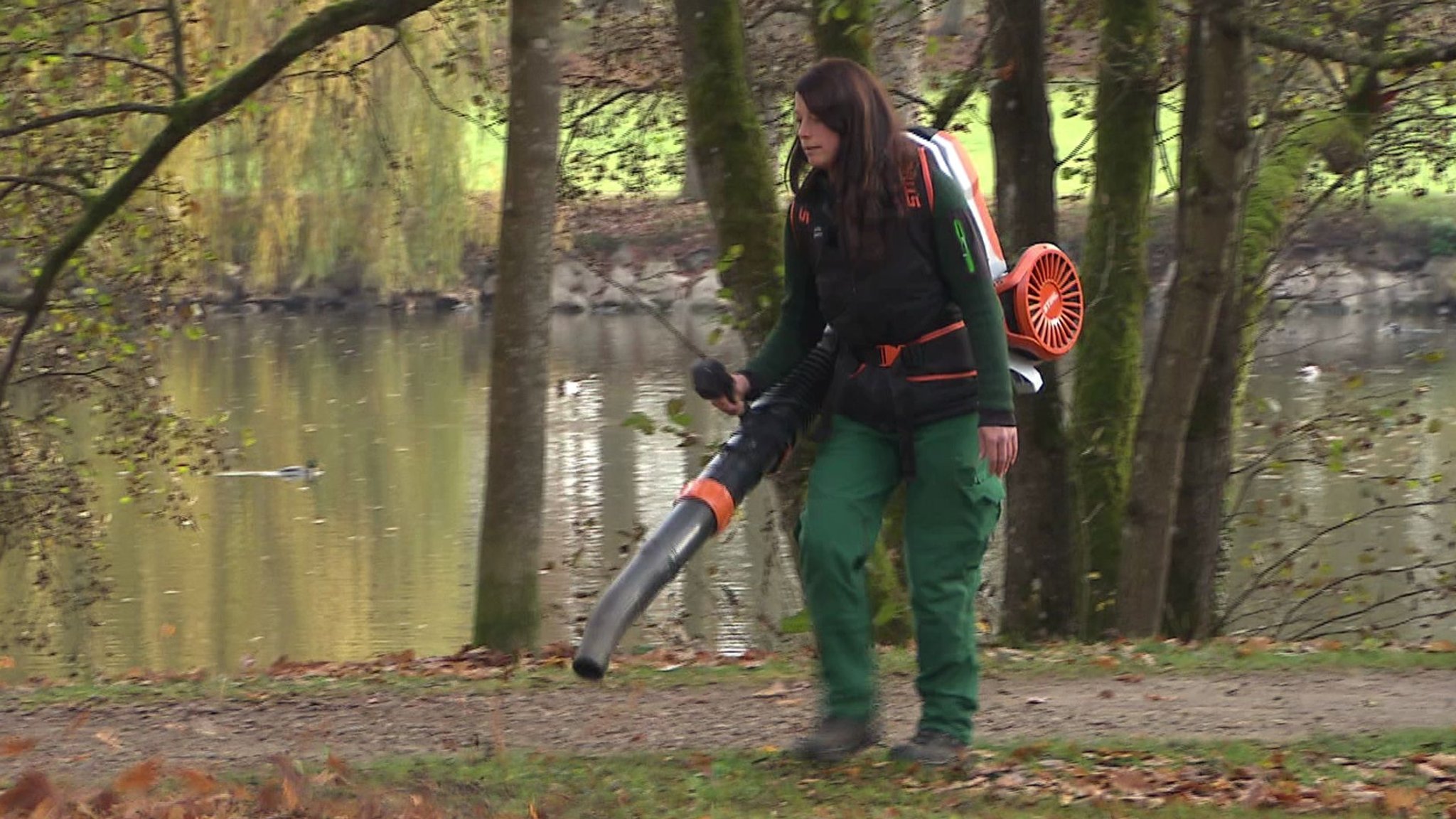 Eine Gärtnerin ist mit einem elektrisch betriebenen Laubbläser im Schlosspark Rosenau unterwegs | Bild: BR/Andi Ebert Eine Gärtnerin ist mit einem elektrisch betriebenen Laubbläser im Schlosspark Rosenau unterwegs