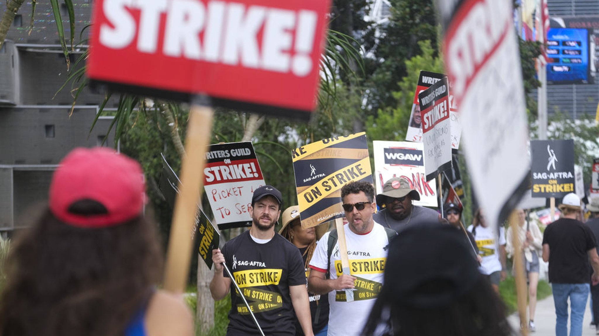 21.09.2023, USA, Los Angeles: Demonstranten halten Plakate während einer Kundgebung vor den Sunset Bronson-Studios.