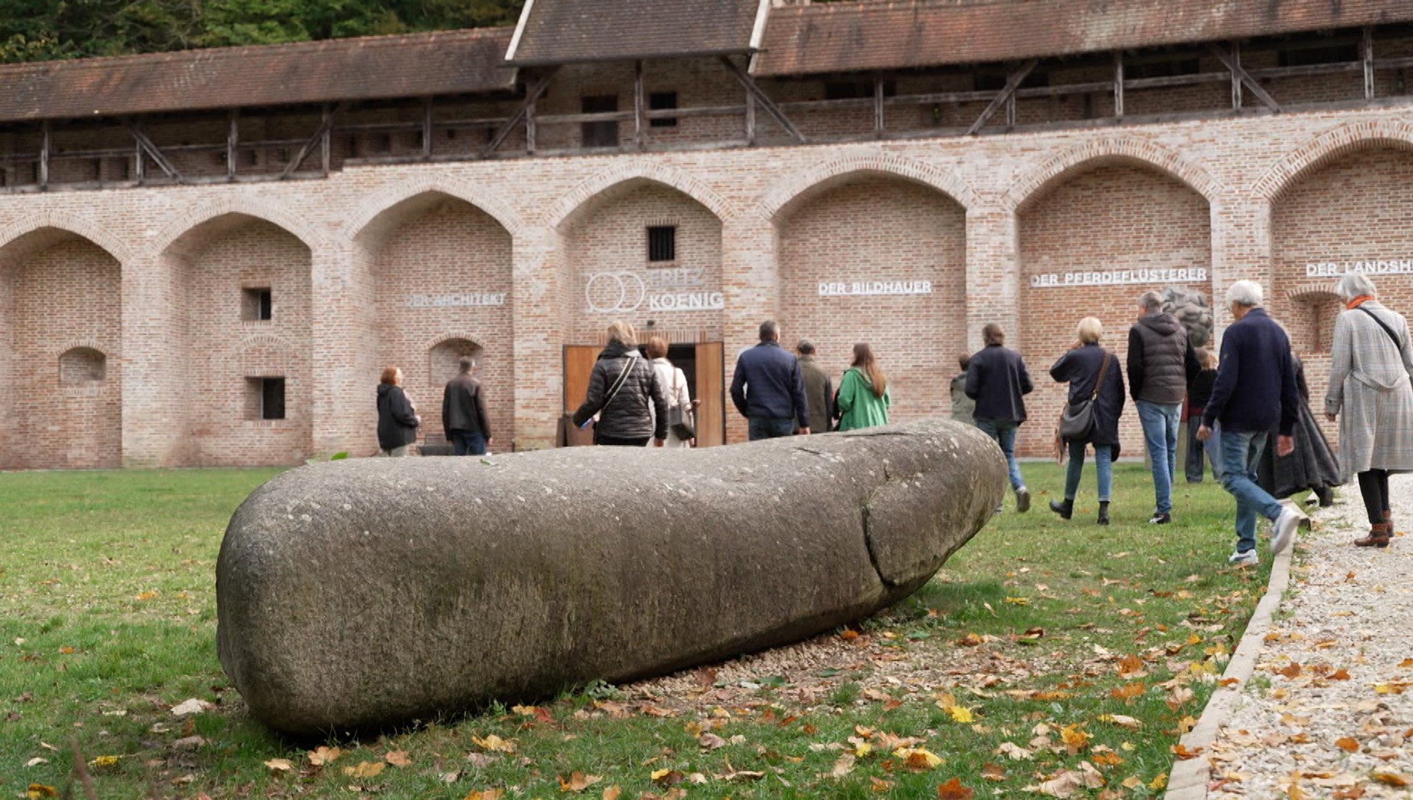 Besucher strömen in eine Ausstellung des Künstlers Fritz Koenig in Landshut.