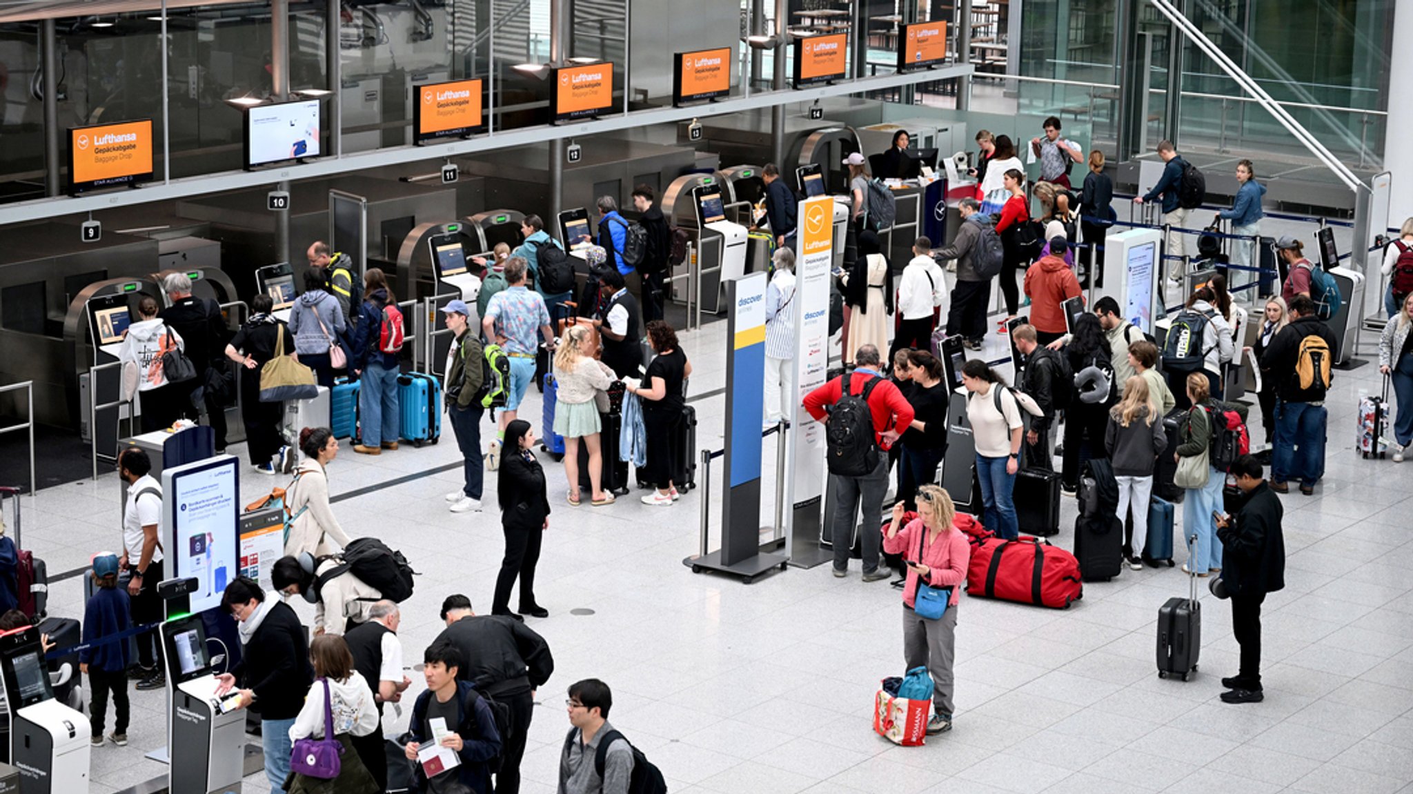 07.06.2025, Bayern, München: Fluggäste stehen bei der Gepäckaufgabe im Terminal an. Der Flughafen München erwartet zu Beginn der Pfingstferien Hunderttausende Fluggäste. Foto: Felix Hörhager/dpa +++ dpa-Bildfunk