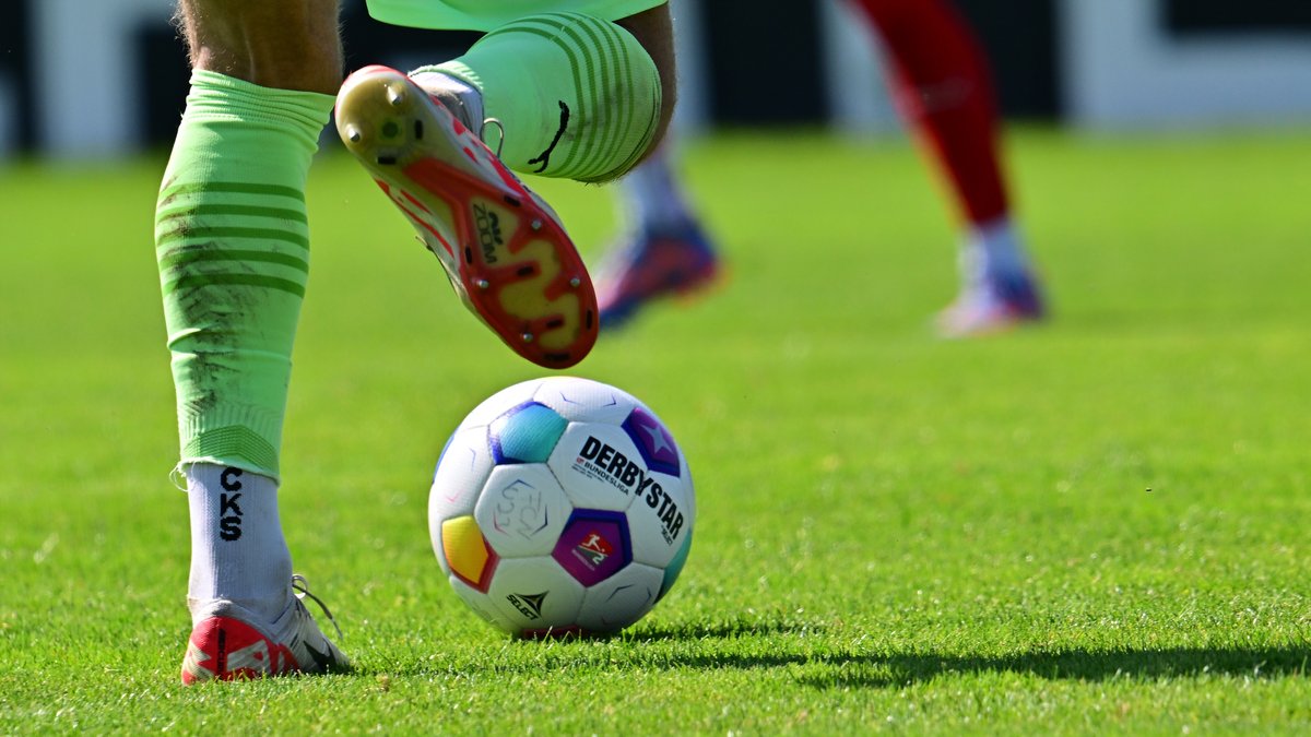 Fußballer-Beine und Regionalliga-Spielball