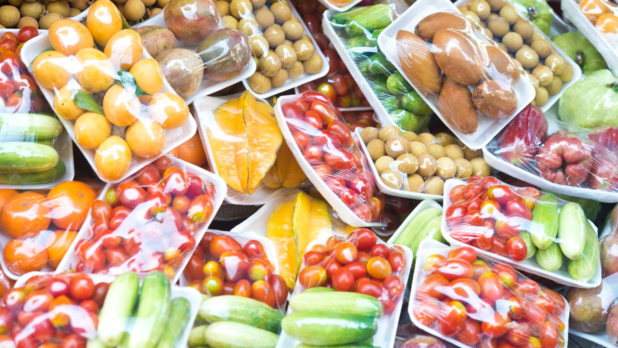 Obst und Gemüse in Plastikverpackungen.