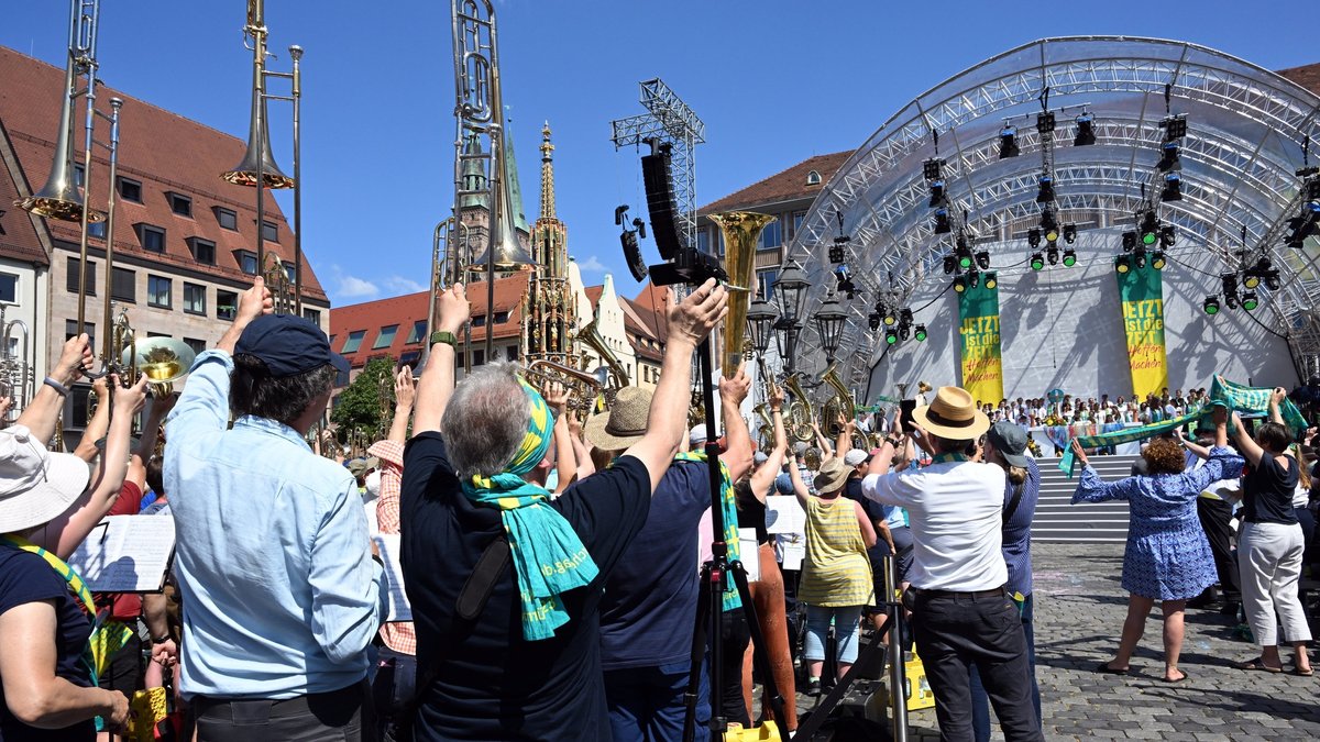 Unter großem Jubel und mit Instrumenten und Schals in der Luft endet der Abschlussgottesdienst des 38. Deutschen Evangelischen Kirchentags auf dem Hauptmarkt in Nürnberg.