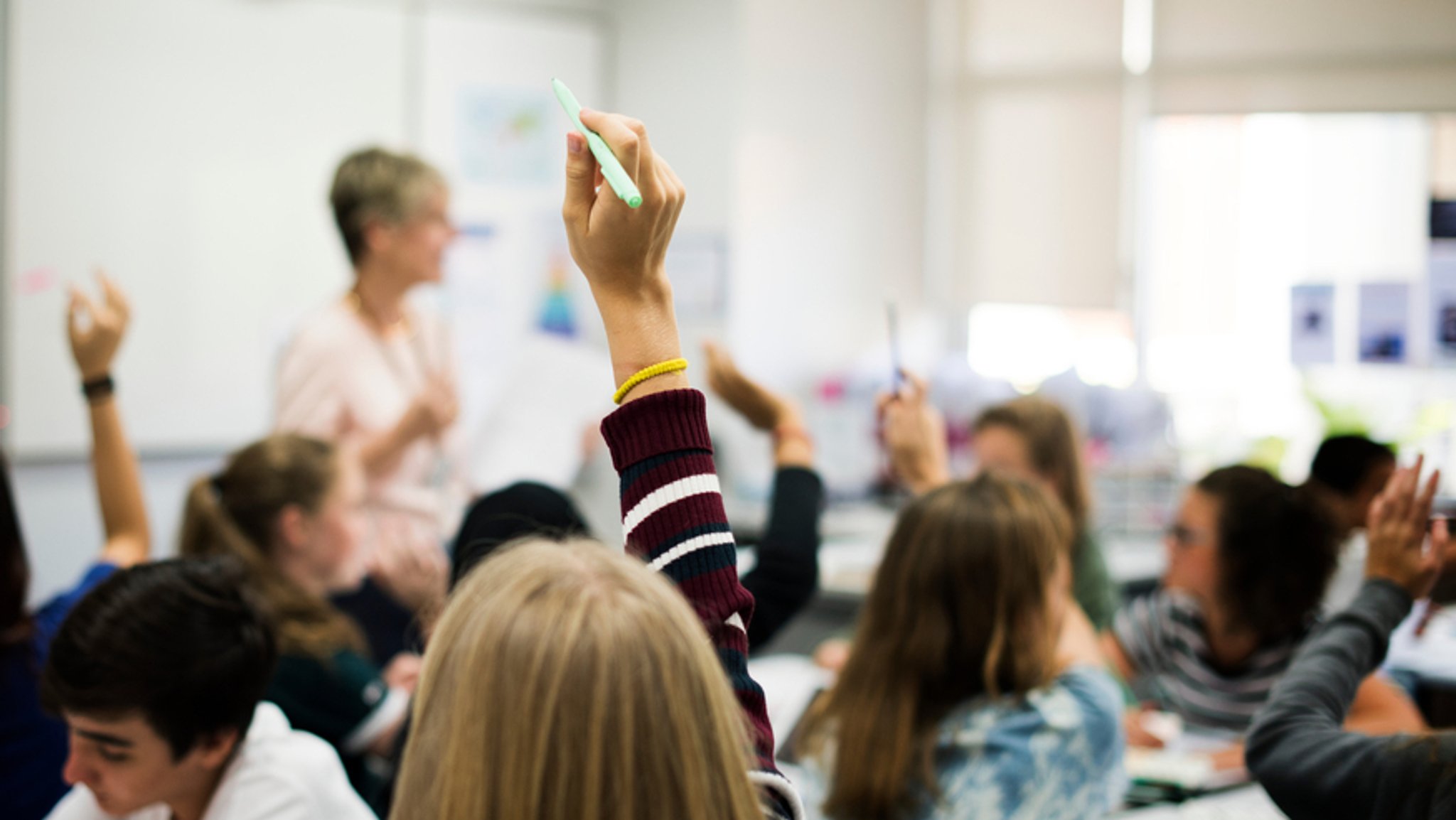 Eine Gruppe von Schülerinnen und Schülern, die sich im Unterricht melden | Bild: stock.adobe.com/rawpixel.com Eine Gruppe von Schülerinnen und Schülern, die sich im Unterricht melden
