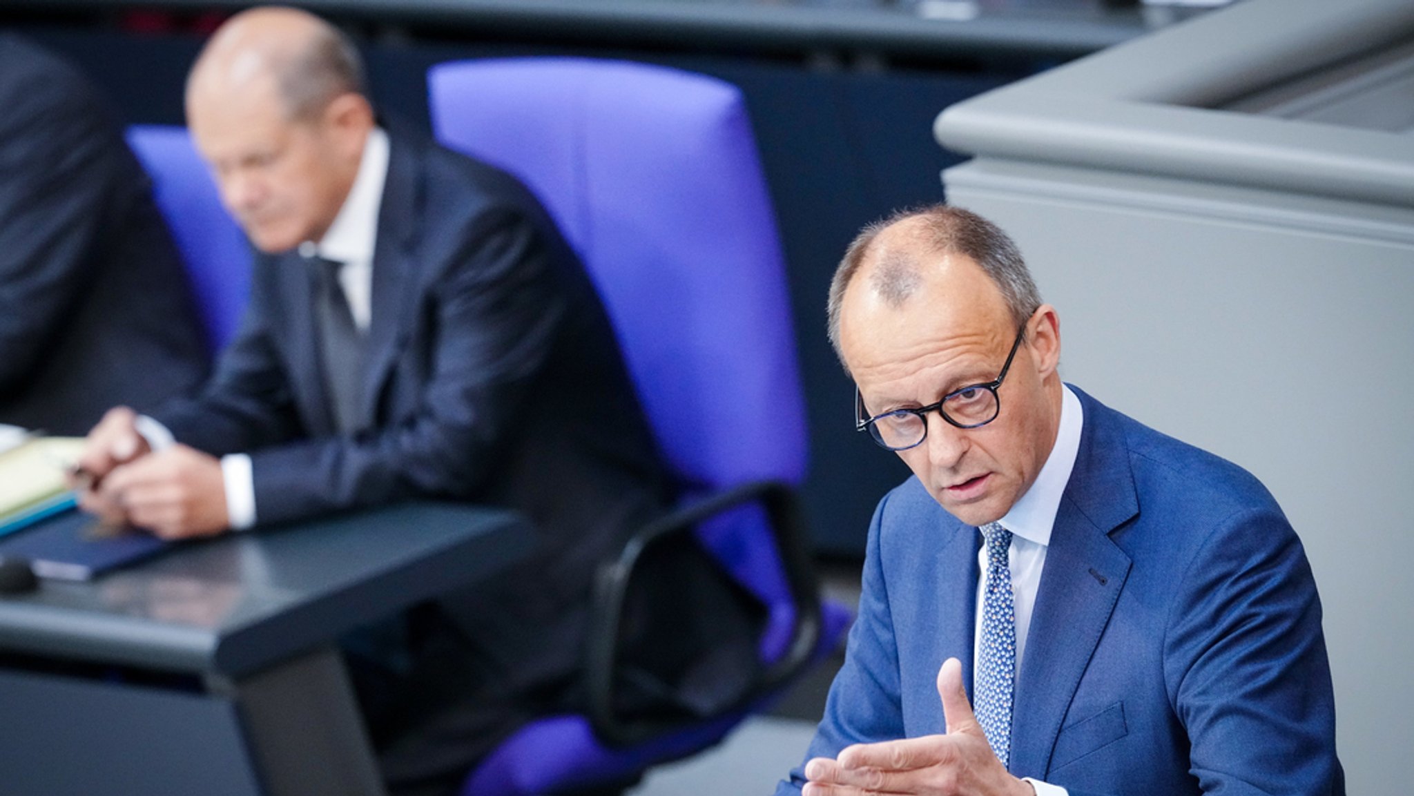 Friedrich Merz spricht in der Generaldebatte der Haushaltswoche im Bundestag neben Bundeskanzler Olaf Scholz (l, SPD).