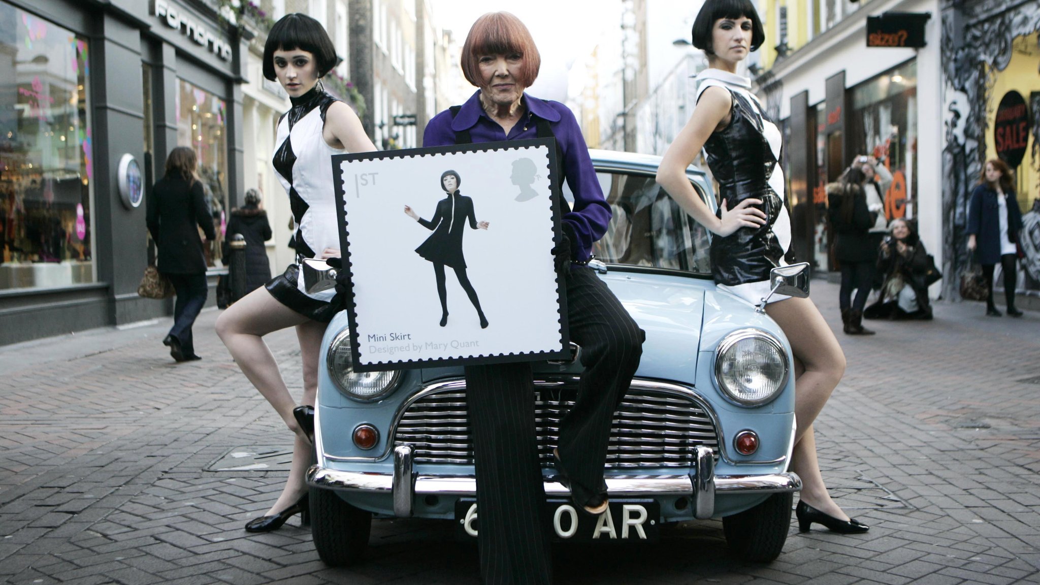 Mary Quant mit Models und einer ihr gewidmeten Briefmarke 2009