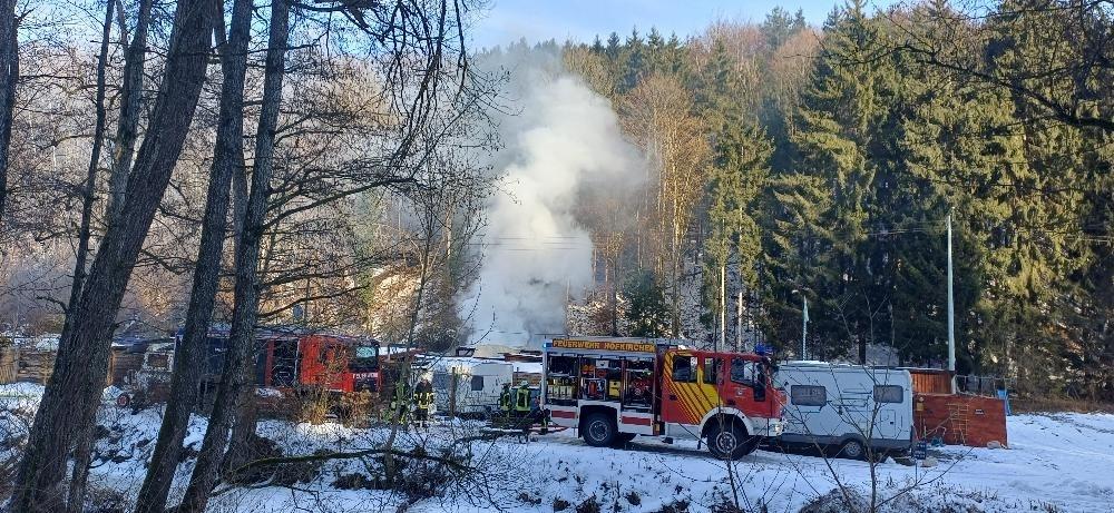 Auf einem Campingplatz steigt Rauch auf.