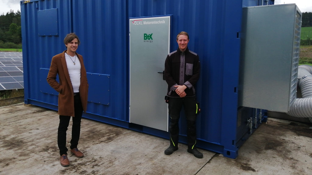 Andy Gradel und Andreas Molle von Btx Energy stehen vor einem Versuchscontainer zur Restholzvergasung in Hof.