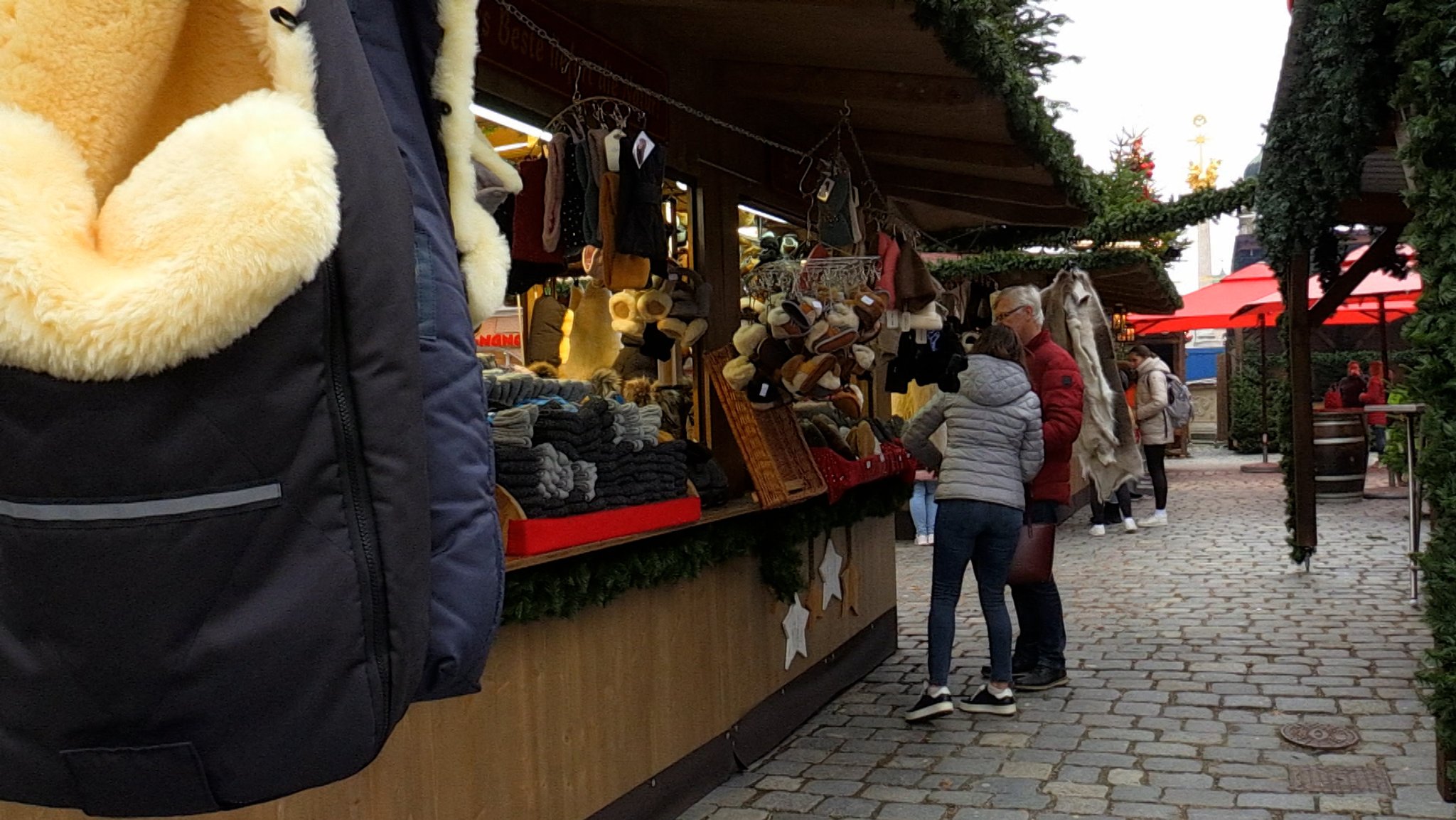 Besucher stehen am Christkindlmarkt in Straubing an einem Warenstand.