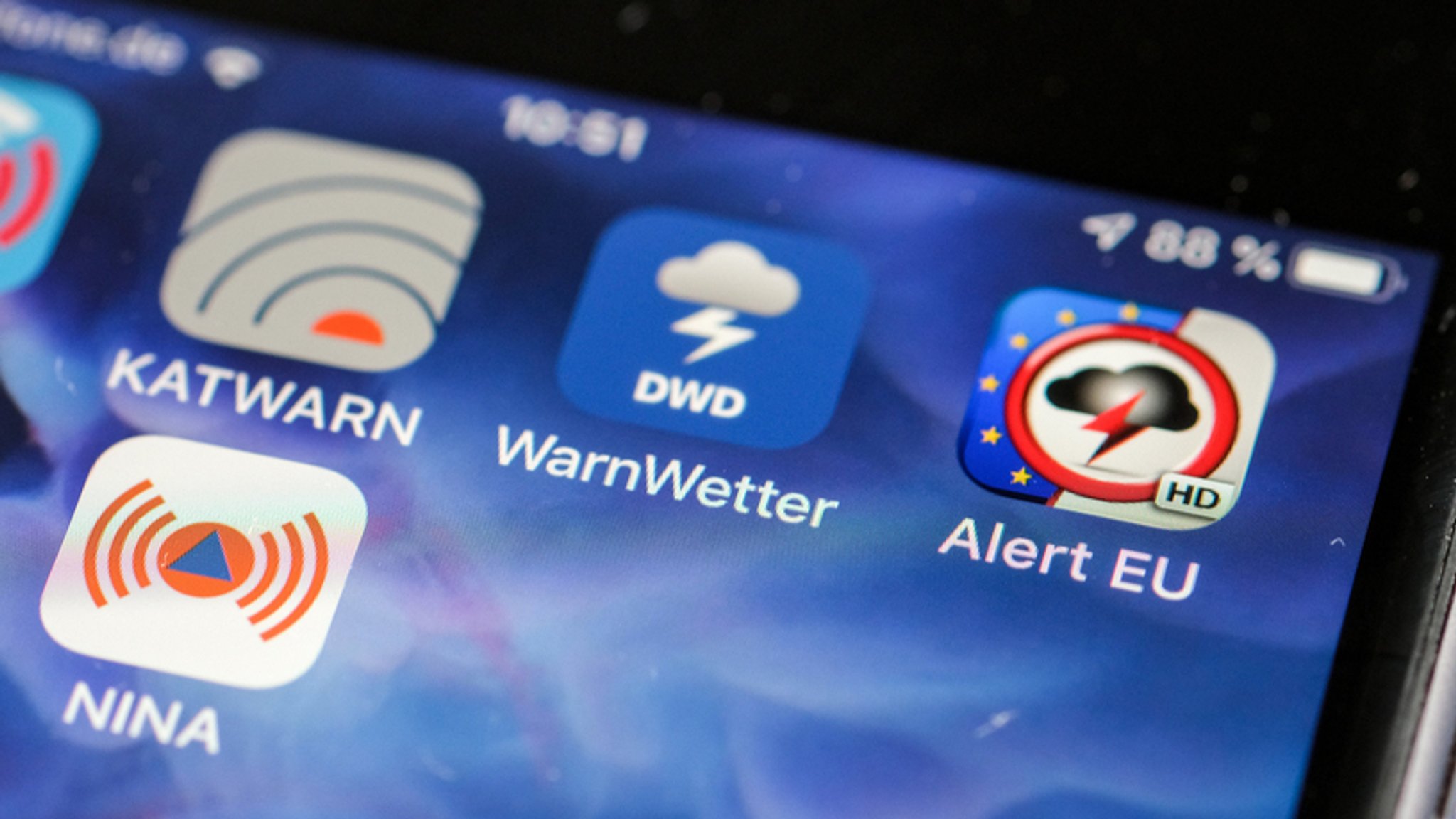 Smartphone-Bildschirm mit Logos von Warn-Apps