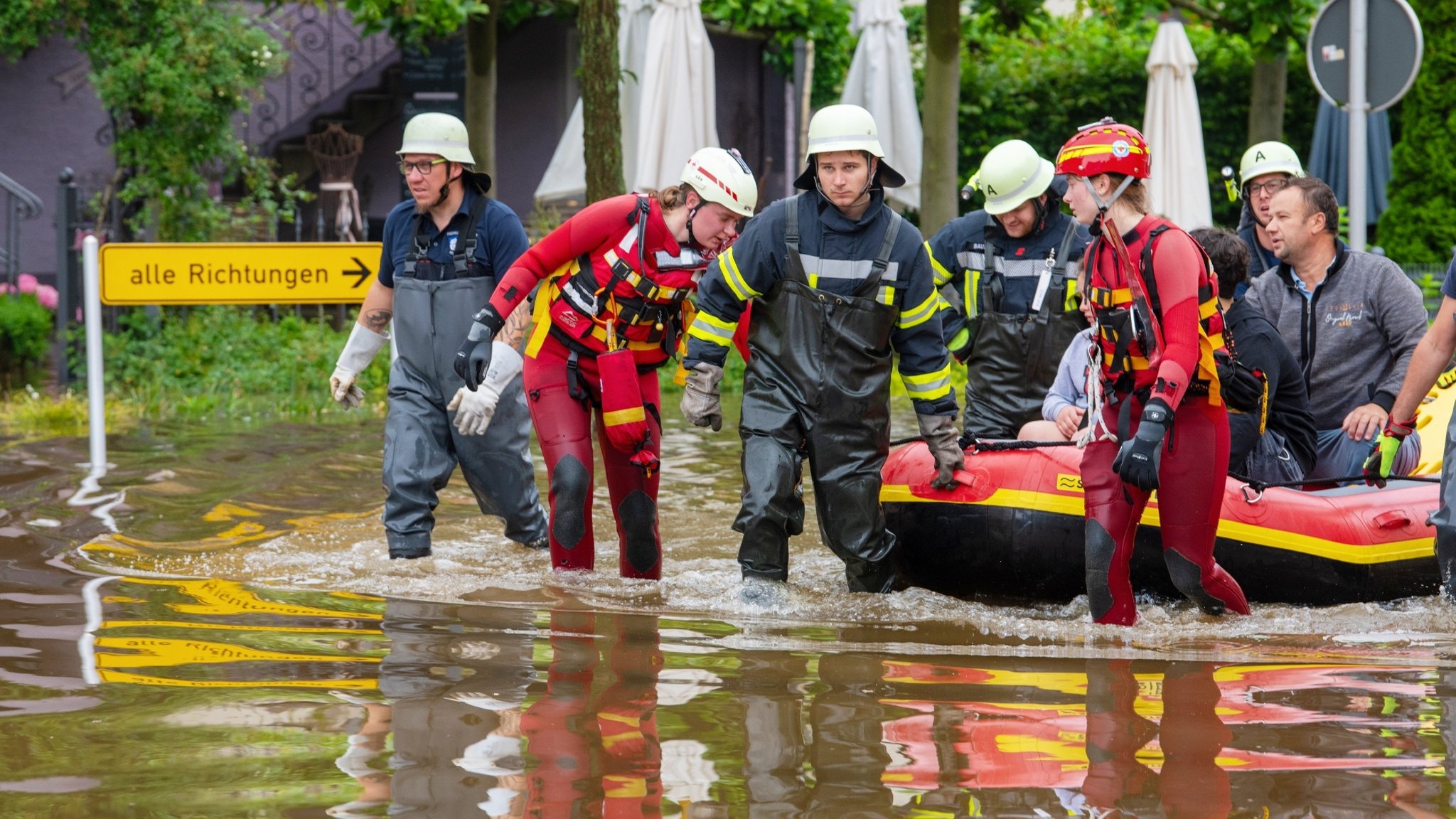 Mit einem Schlauchboot holen Feuerwehr und Wasserretter Anwohner aus ihren überfluteten Häusern in Wertingen.