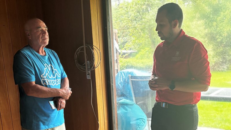 Giovanni Ape und Caritas-Mitarbeiter Alexander Böse stehen in der vom Hochwasser zerstörten Wohnung von Giovanni Apel und reden miteinander.