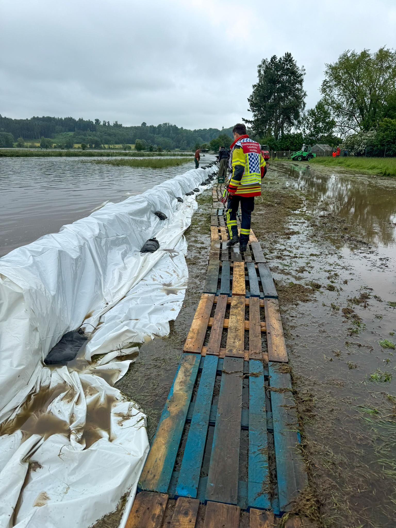 Den großflächig über die Ufer getretenen Fluss Schmutter versuchten Einsatzkräfte aus Landkreis Ansbach und Stadt Ansbach zu bändigen. Sie halfen unter anderem beim Schlichten von Sandsäcken.