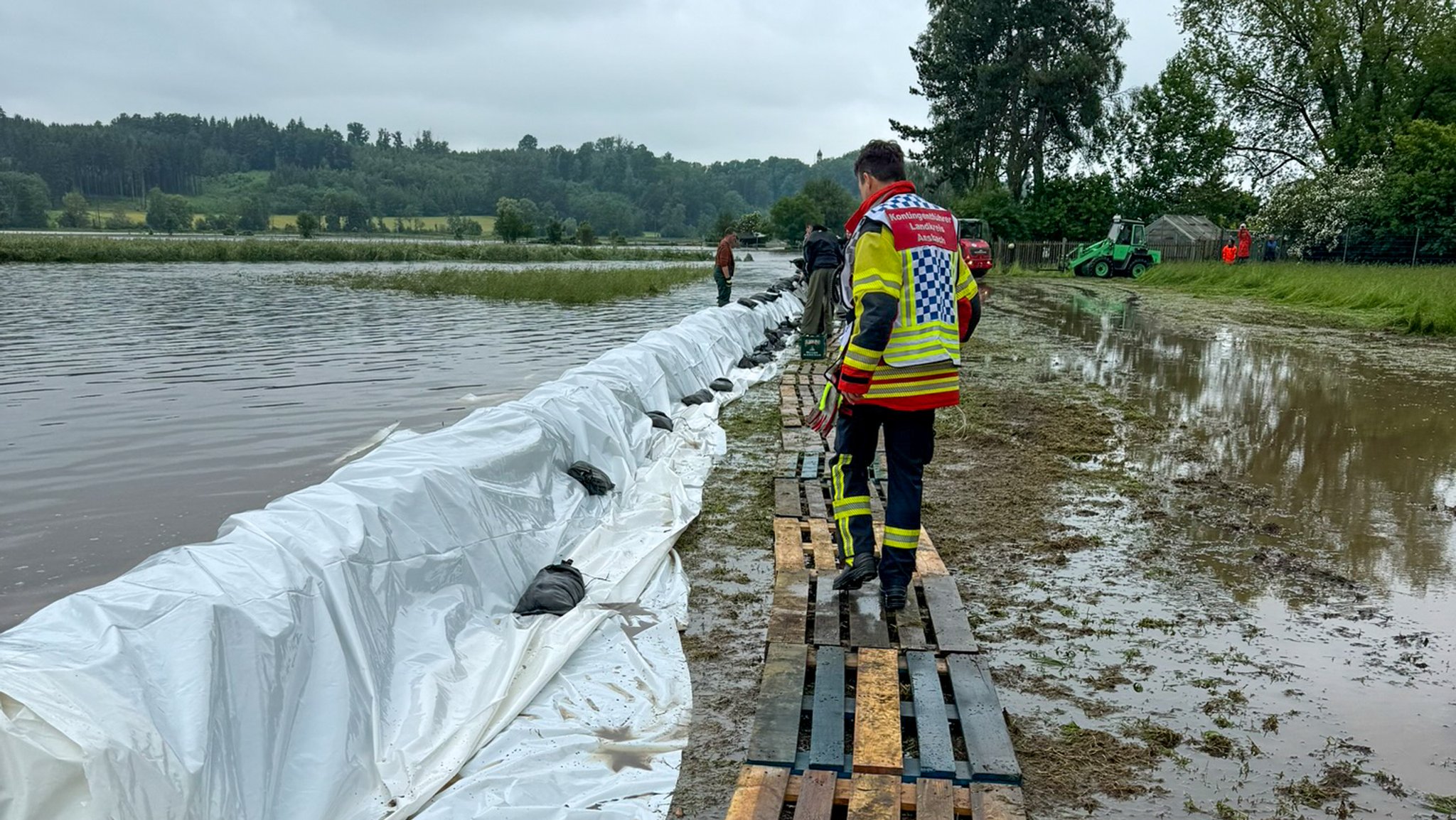 Den großflächig über die Ufer getretenen Fluss Schmutter versuchten Einsatzkräfte aus Landkreis Ansbach und Stadt Ansbach zu bändigen. Sie halfen unter anderem beim Schlichten von Sandsäcken.