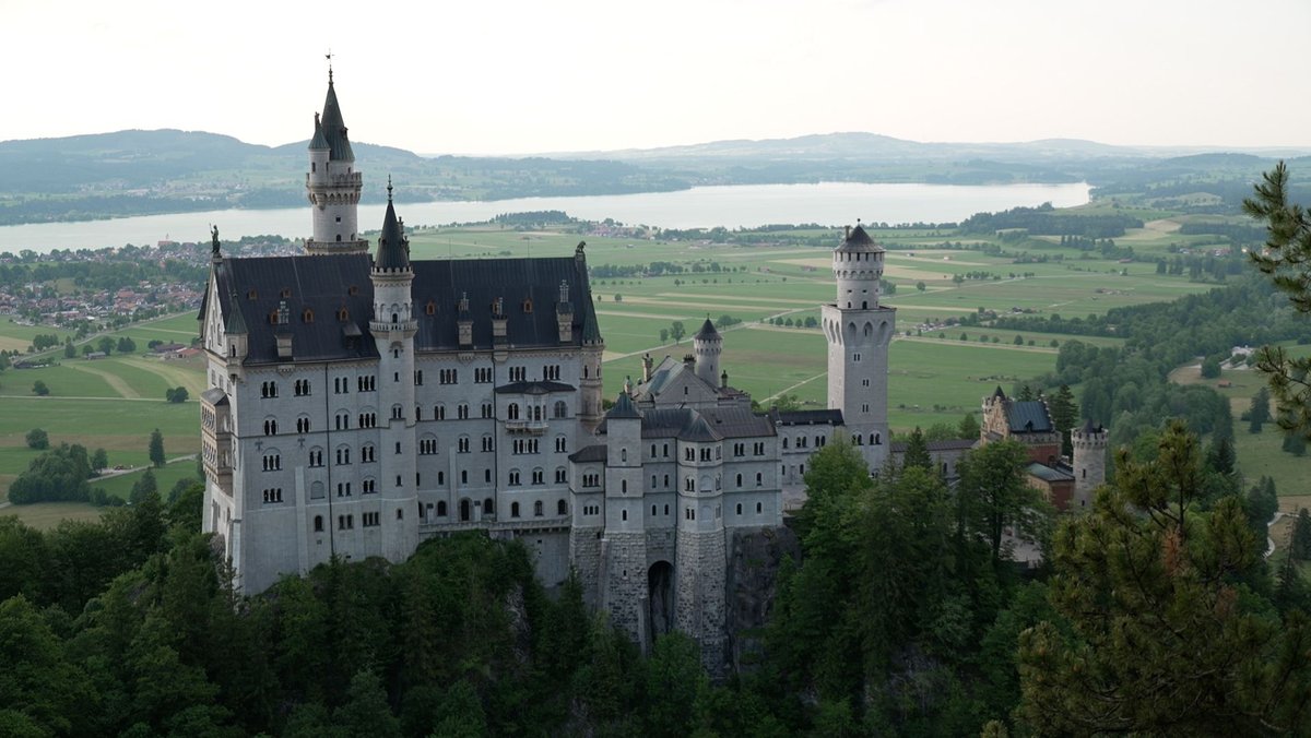 Blick auf das Schloss Neuschwanstein mit dem Forggensee im Hintergrund.