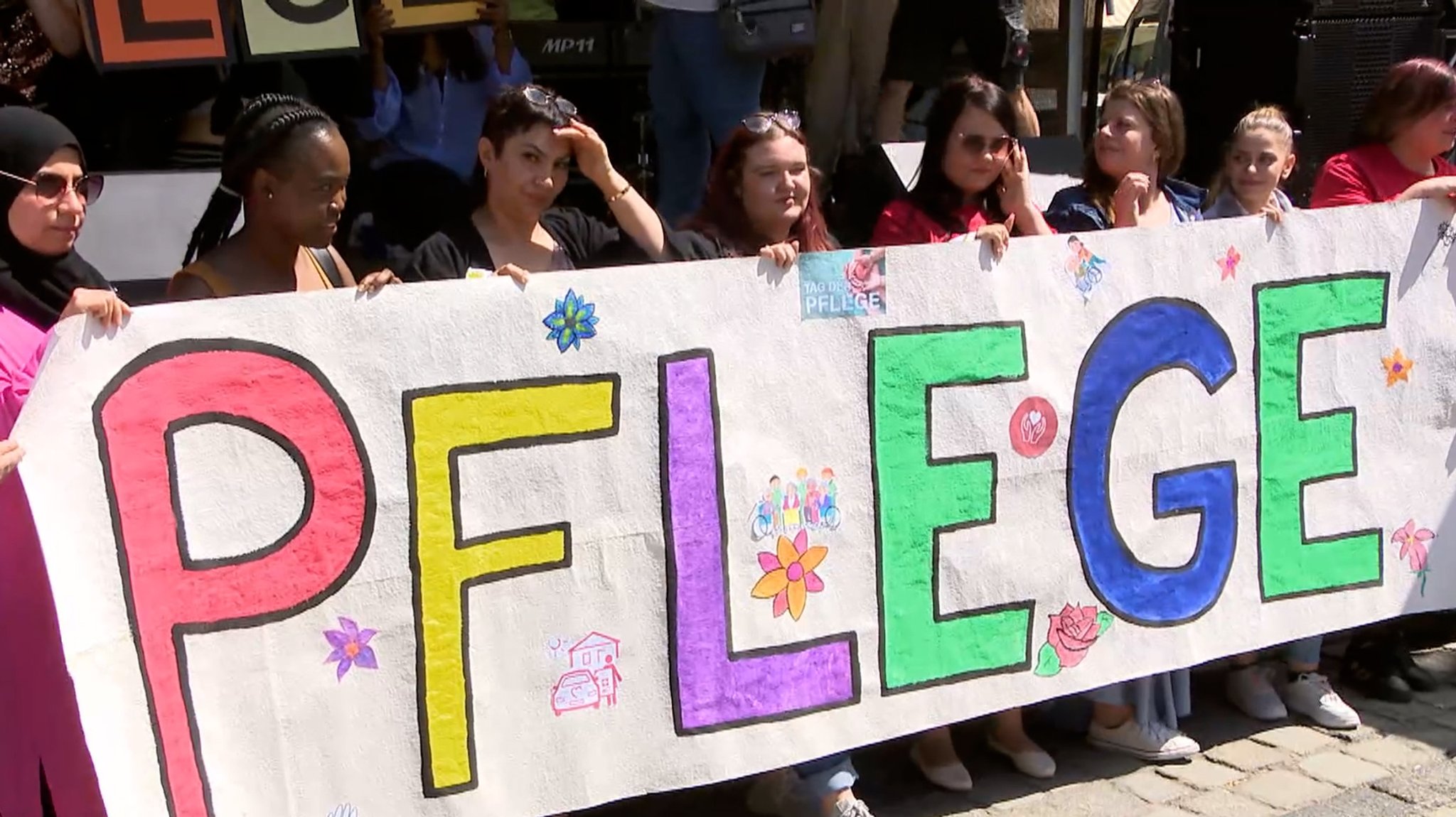 Pflegeschüler feiern ihren Beruf, hier mit Banner, am Tag der Pflege.