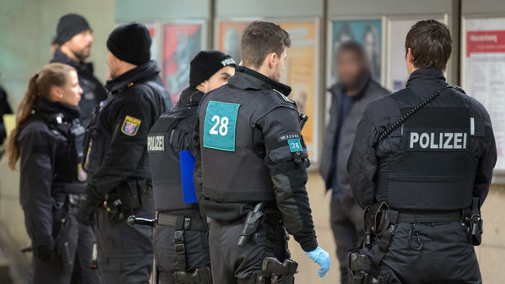 Polizisten umstellen einen dunkelhäutigen Mann während einer Polizeikontrolle am Frankfurter Hauptbahnhof. 