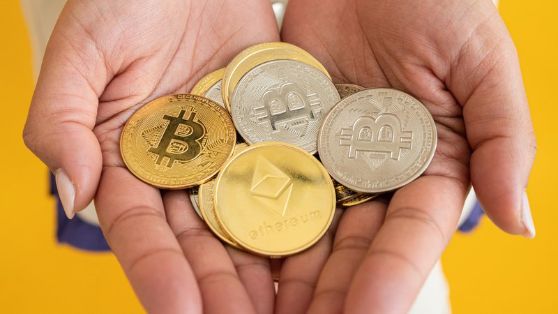 Frau hält Münzen von Kryptowährungen