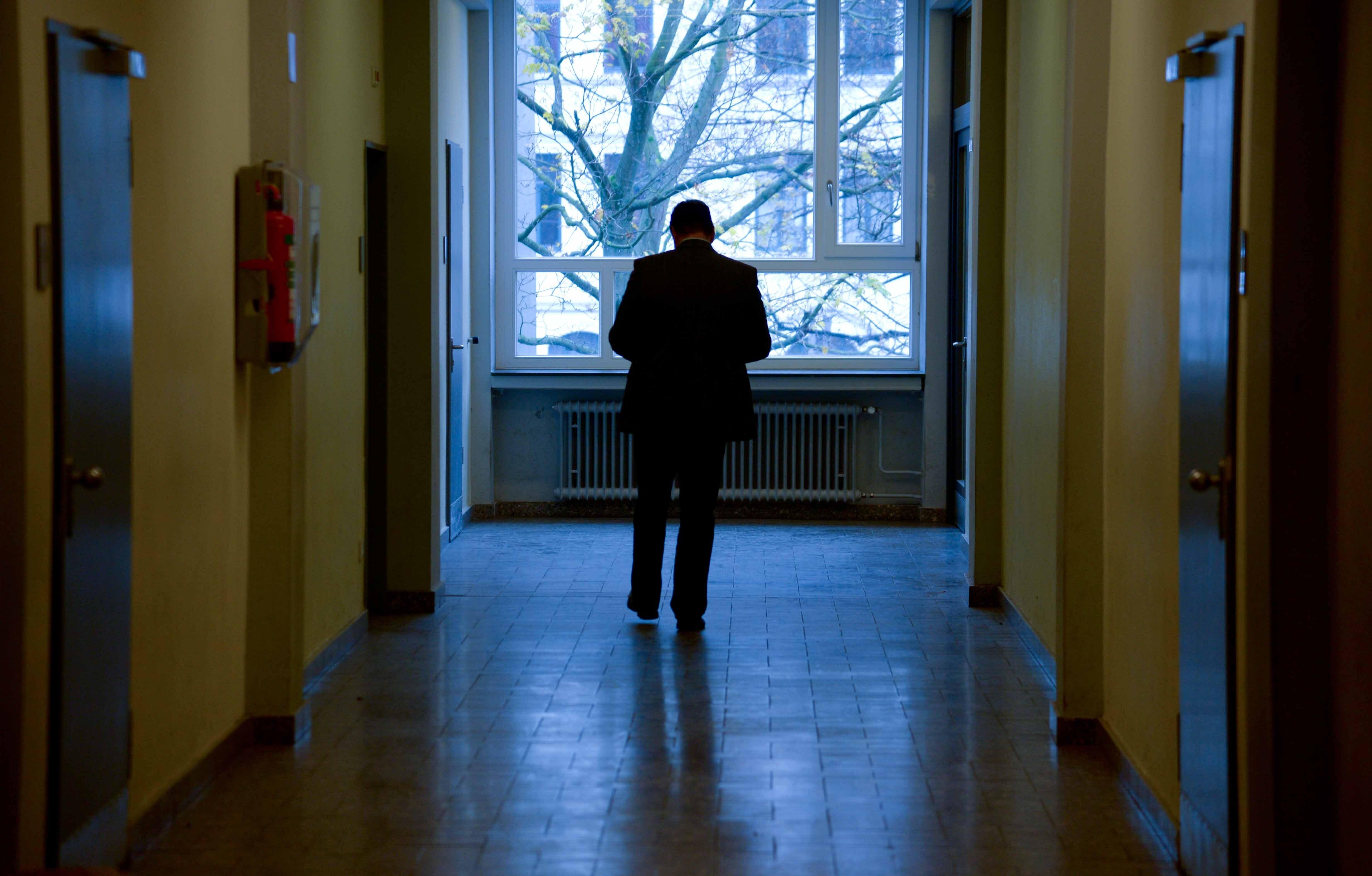 Ein Lehrer geht über den Flur in einem Schulhaus. 