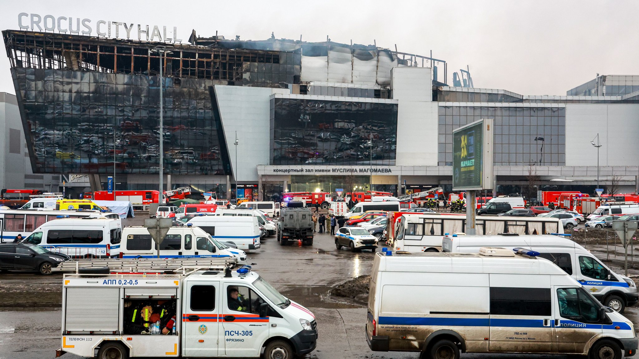 Einsatzfahrzeuge vor ausgebrannter Fassade