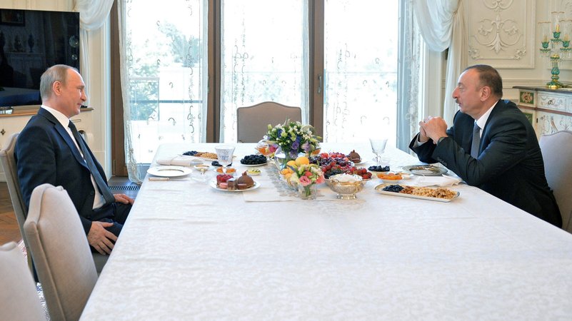 Die beiden Politiker sitzen an einer reich gedeckten Tafel | Bild: Alexei Druginin/RIA Nowosti/Picture Alliance Die beiden Politiker sitzen an einer reich gedeckten Tafel