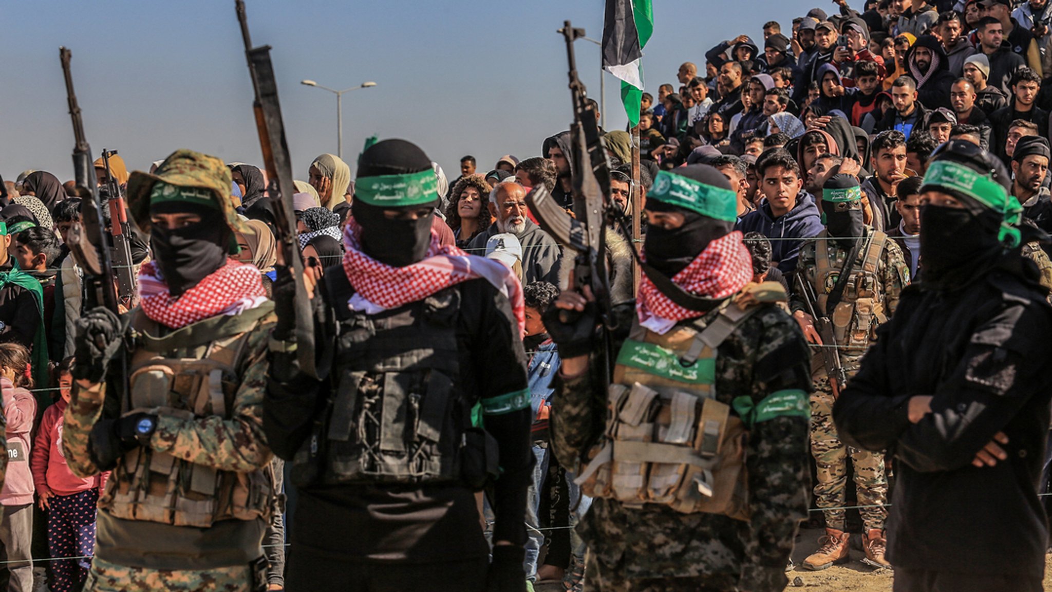 Kämpfer des Islamischen Dschihad und der Al-Kassam-Brigaden, des militärischen Flügels der Hamas, stehen in Formation, während Palästinenser die Übergabe von drei israelischen Geiseln an Vertreter des Roten Kreuzes im südlichen Gazastreifen beobachten. (Archivbild vom 15.2.25) | Bild: dpa-Bildfunk/Abed Rahim Khatib Kämpfer des Islamischen Dschihad und der Al-Kassam-Brigaden, des militärischen Flügels der Hamas, stehen in Formation, während Palästinenser die Übergabe von drei israelischen Geiseln an Vertreter des Roten Kreuzes im südlichen Gazastreifen beobachten. (Archivbild vom 15.2.25)