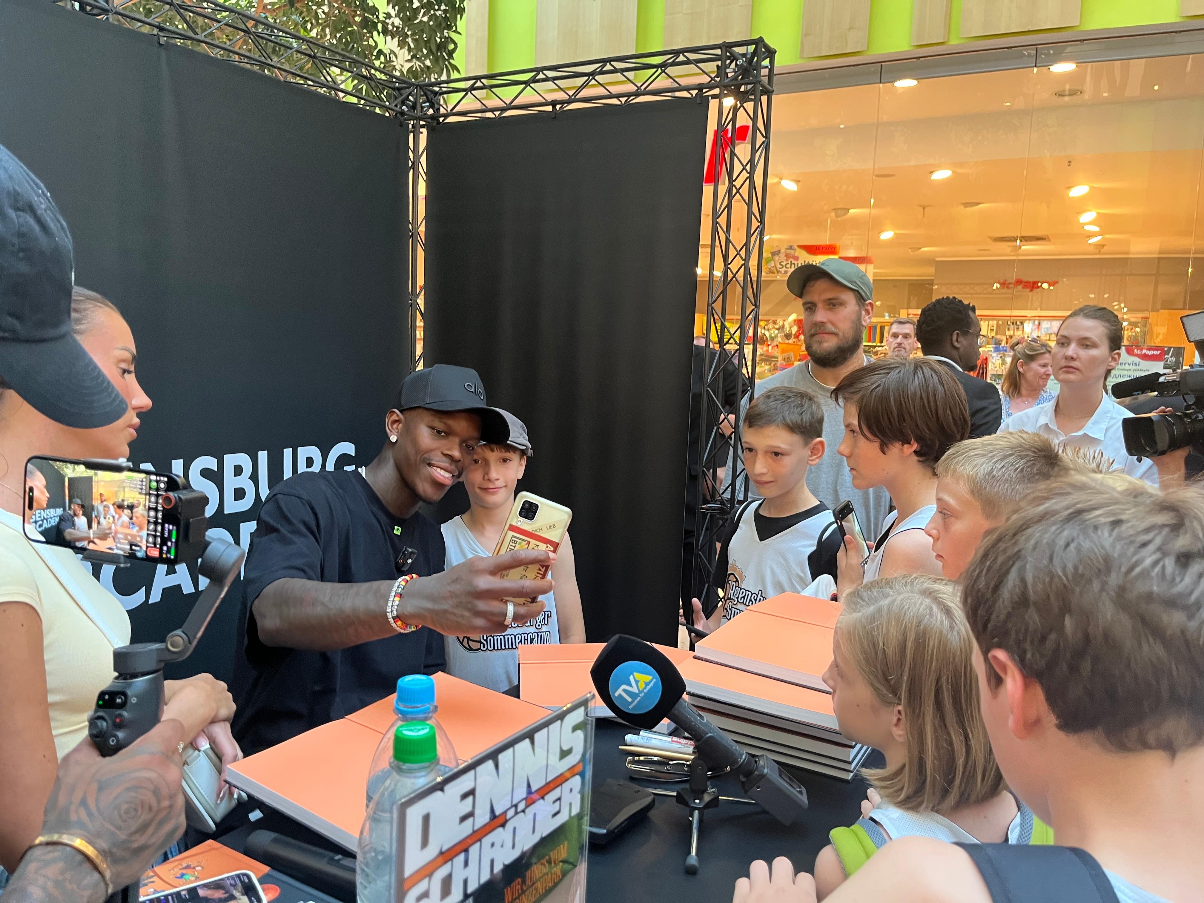 Basketballstar Dennis Schröder umzingelt von Fans in Regensburg. Hier hat er am Mittwoch (13.08.) sein neues Kinderbuch vorgestellt.