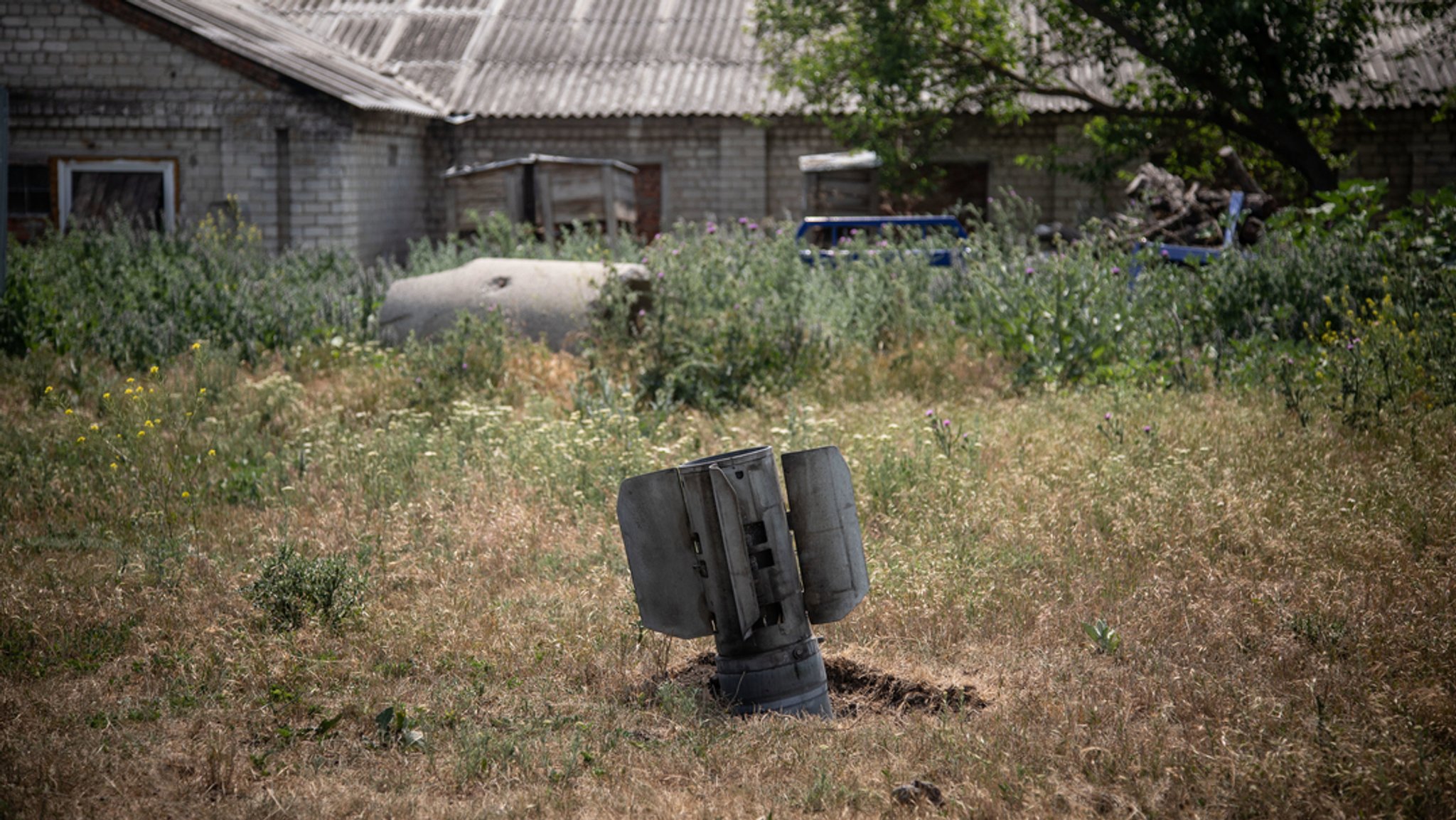 03.07.2022, Ukraine, Slowjansk: Überreste einer Rakete stecken in der Nähe eines Bauernhofs im Dorf Majaky am Stadtrand im Boden. 