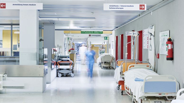Krankenhauspersonal und Betten auf einem Krankenhausgang | Bild:stock.adobe.com/upixa