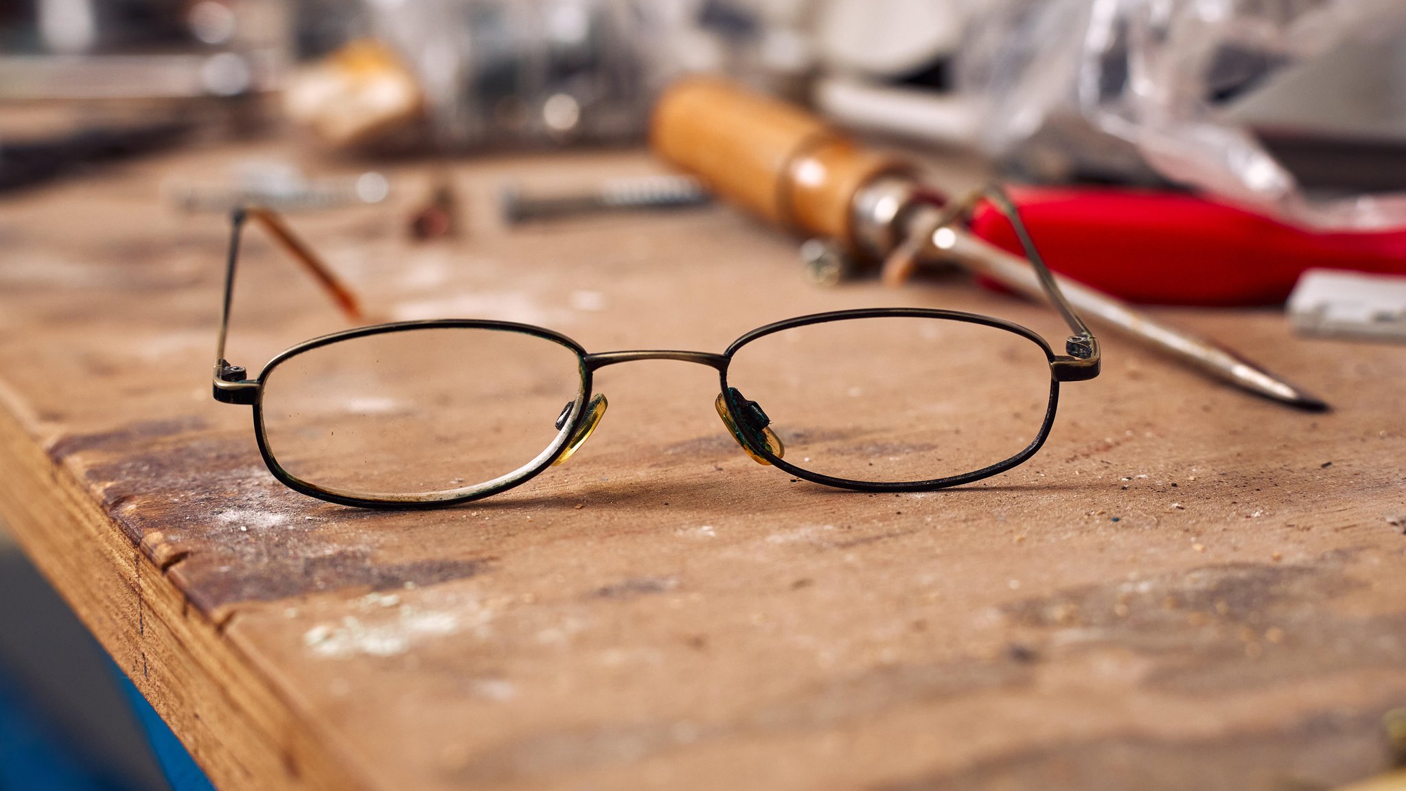 Kaputte Brille liegt auf einer Werkbank